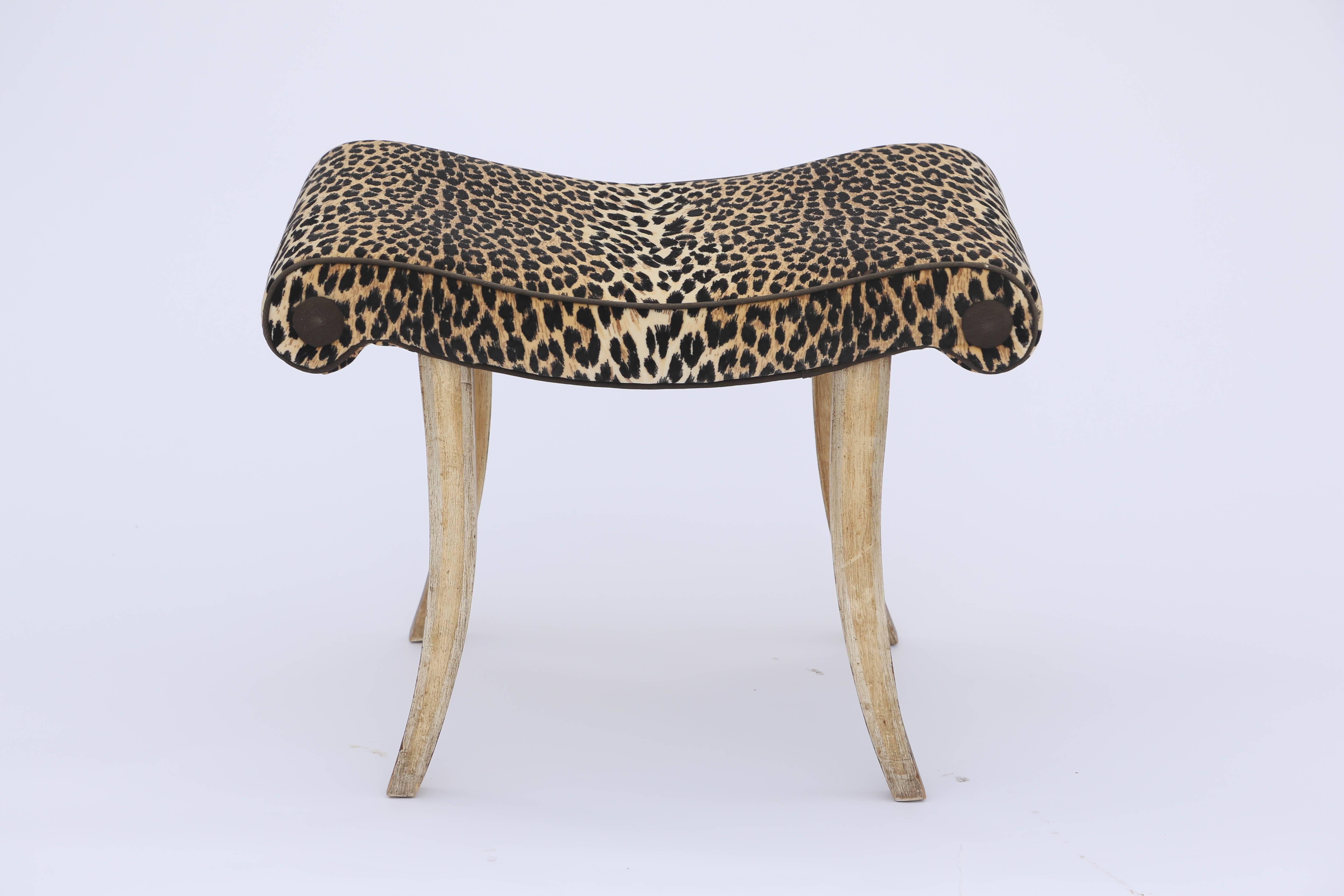 Bench, having a serpentine seat, with scrolling sides, upholstered in vintage Scalamandre leopard velvet, finished with black piping and buttons, raised on four, painted, fielded, spayed legs.

Stock ID: D9505