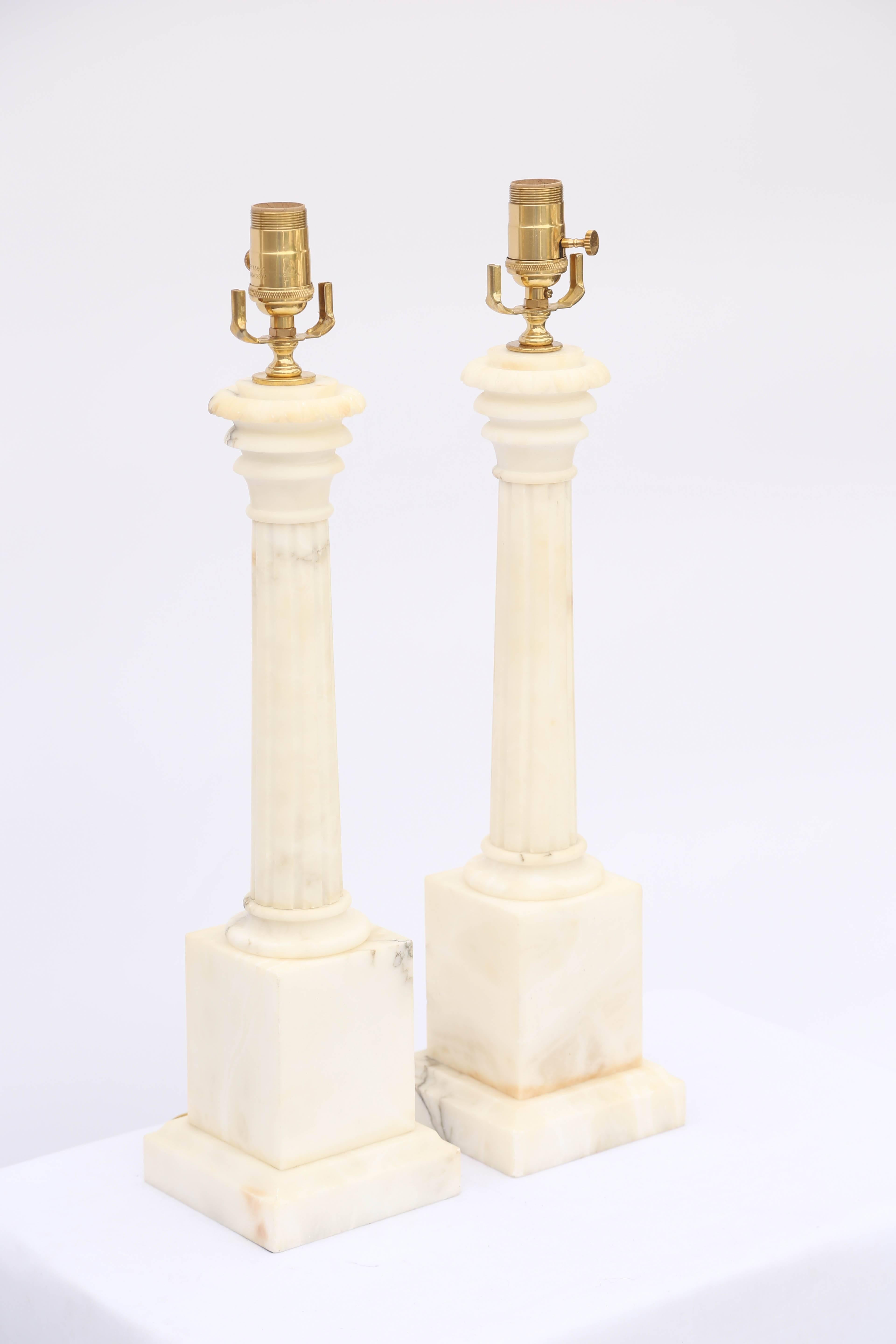 Pair of lamps, of carved alabaster, each a fluted column, on graduated, square plinth. 

Stock ID: D2846.