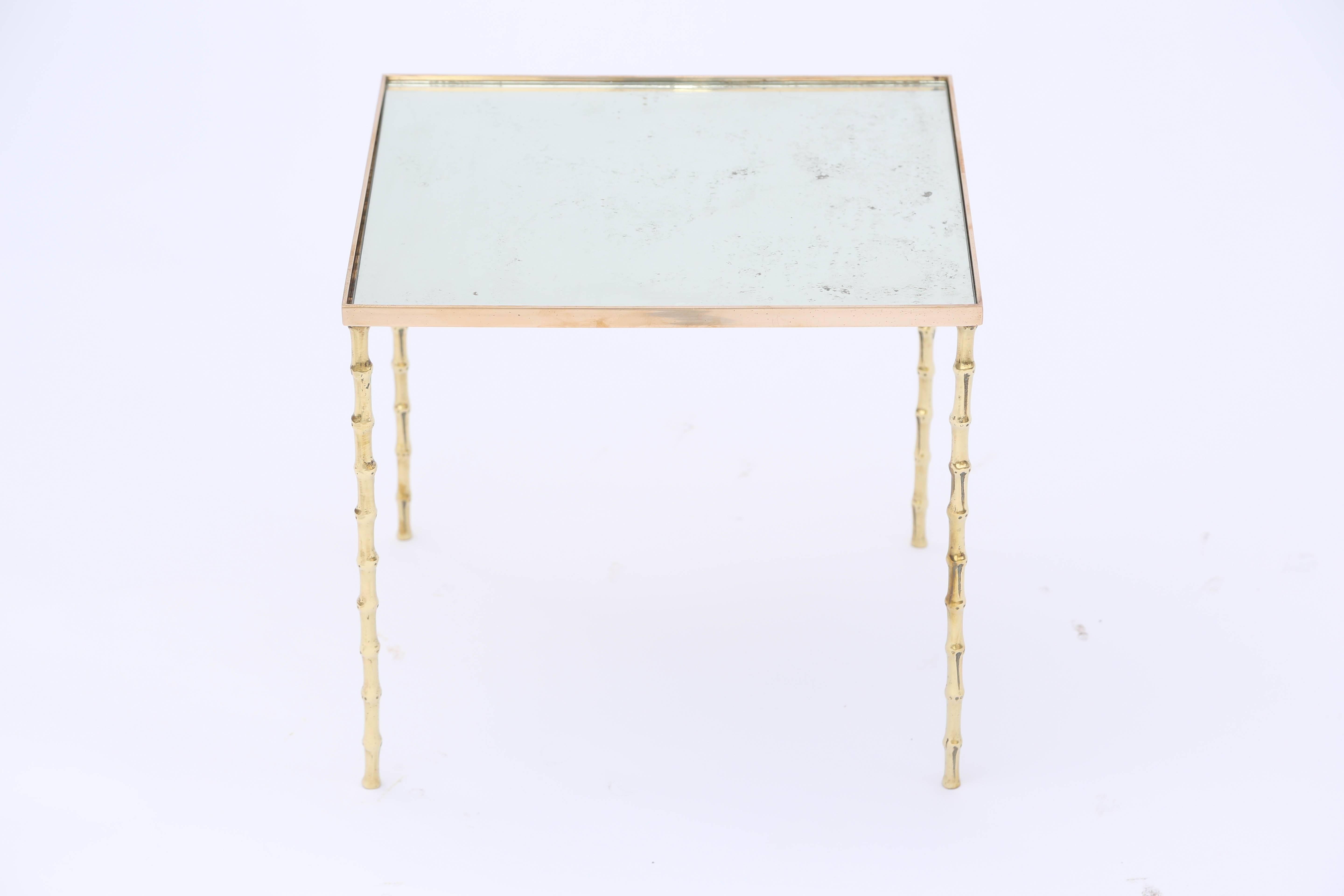 Side table, in the style of Maison Bagues, having a rectangular top of spotted mirror plate, inset on a base of polished brass, raised on four faux bamboo legs.

Stock ID: 7406.