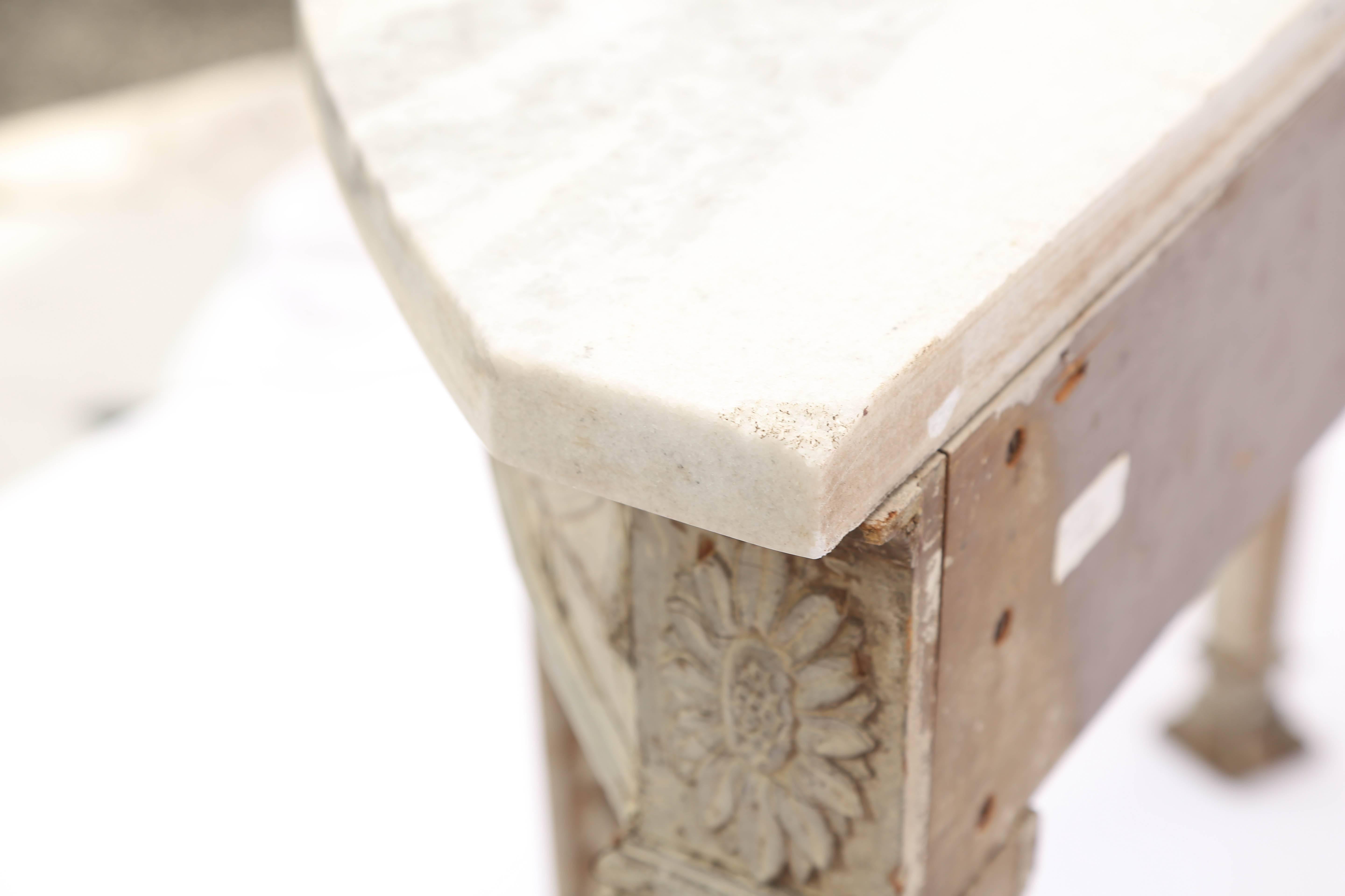Console table, having a D-shaped top of white marble, on conforming table base, with a painted finish showing natural wear, its apron out-carved with swag festooning, raised on square-section, tapering legs, decorated with graduating husking, ending