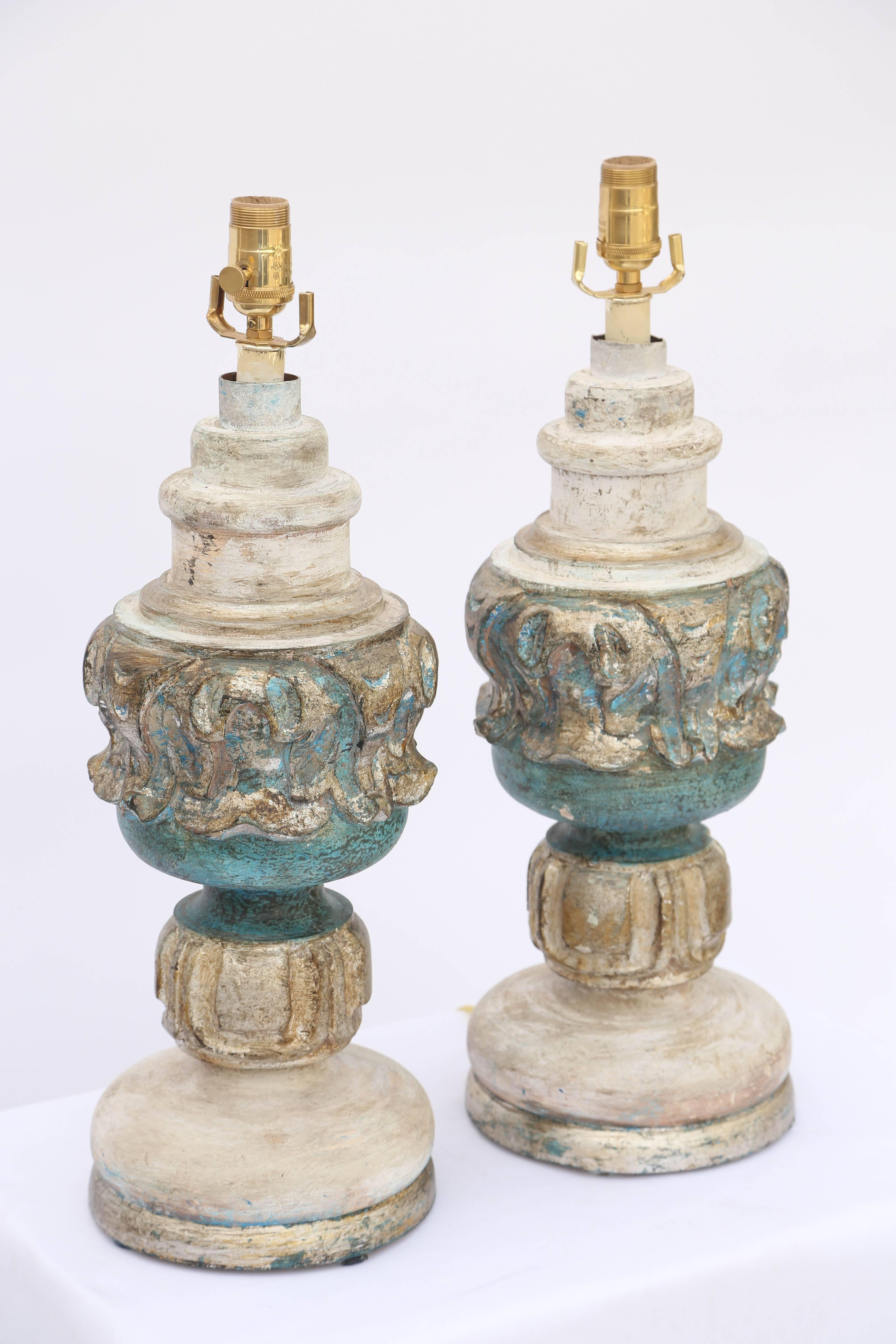 Paire de lampes de table, peintes et dorées à la feuille, chaque corps en forme d'urne décorée de sculptures classiques, reposant sur un pied rond étagé.

Stock ID : D6459