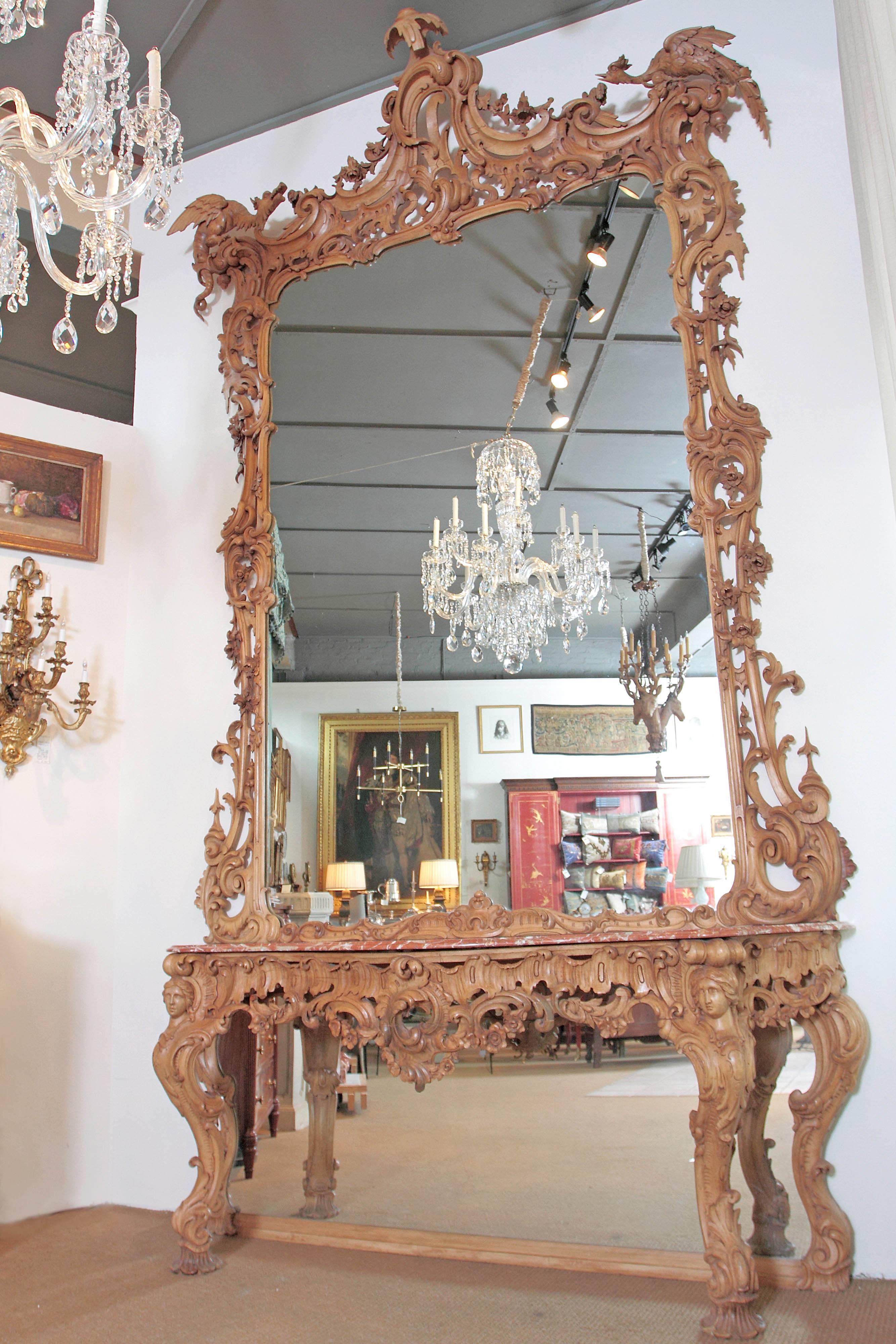 George III Irish Rococo style carved pine pier mirror and matching marble topped table. The crest of the mirror frame is carved with scroll-work, roses, acanthus foliage and shell forms. A two-legged winged dragon with barbed tail surmounts the top