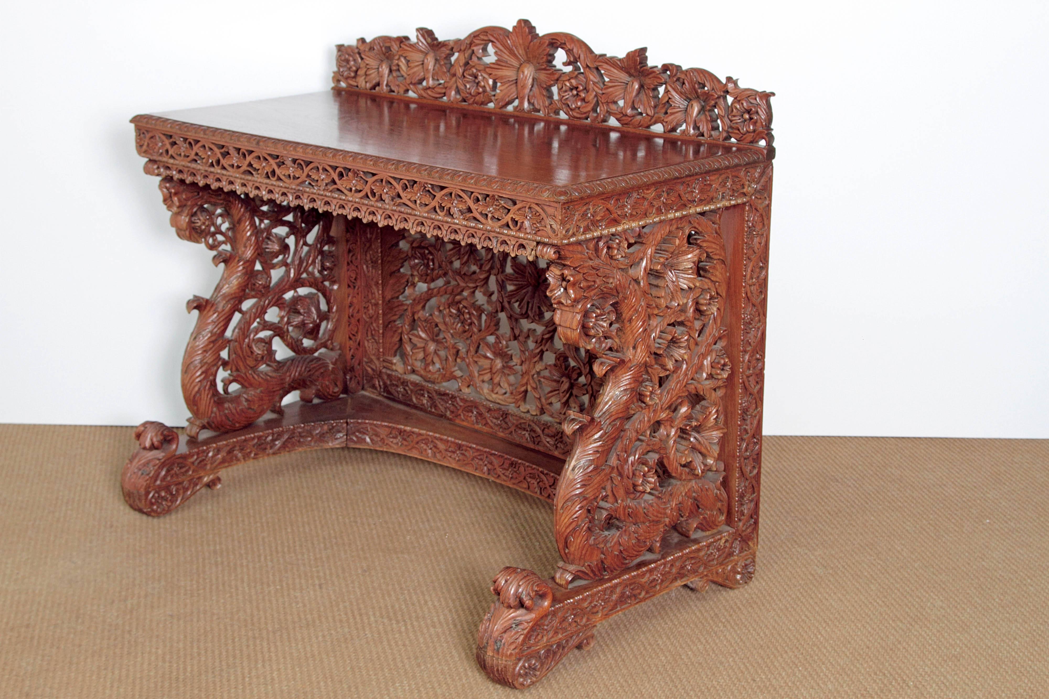 An intricately carved and pierced Anglo-Indian sideboard in rosewood with ornate openwork in an all-over floral design and scrolling acanthus leaves. Solid top and carved back, apron and sides. A carved shelf at the bottom. 

India, mid-19th