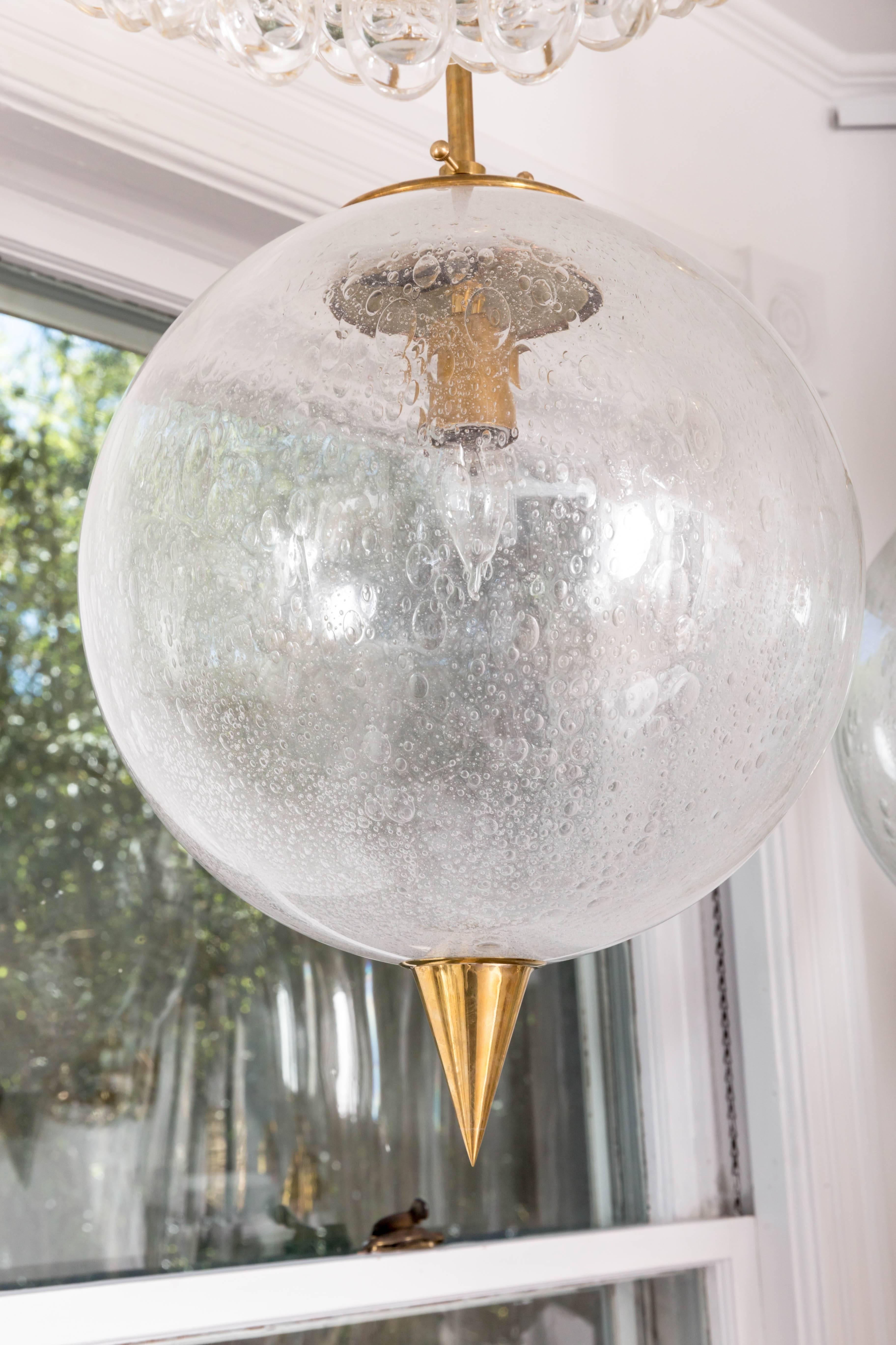 Contemporary Spherical Clear Glass Pendant with Inclusive Air Bubbles and Brass Details For Sale