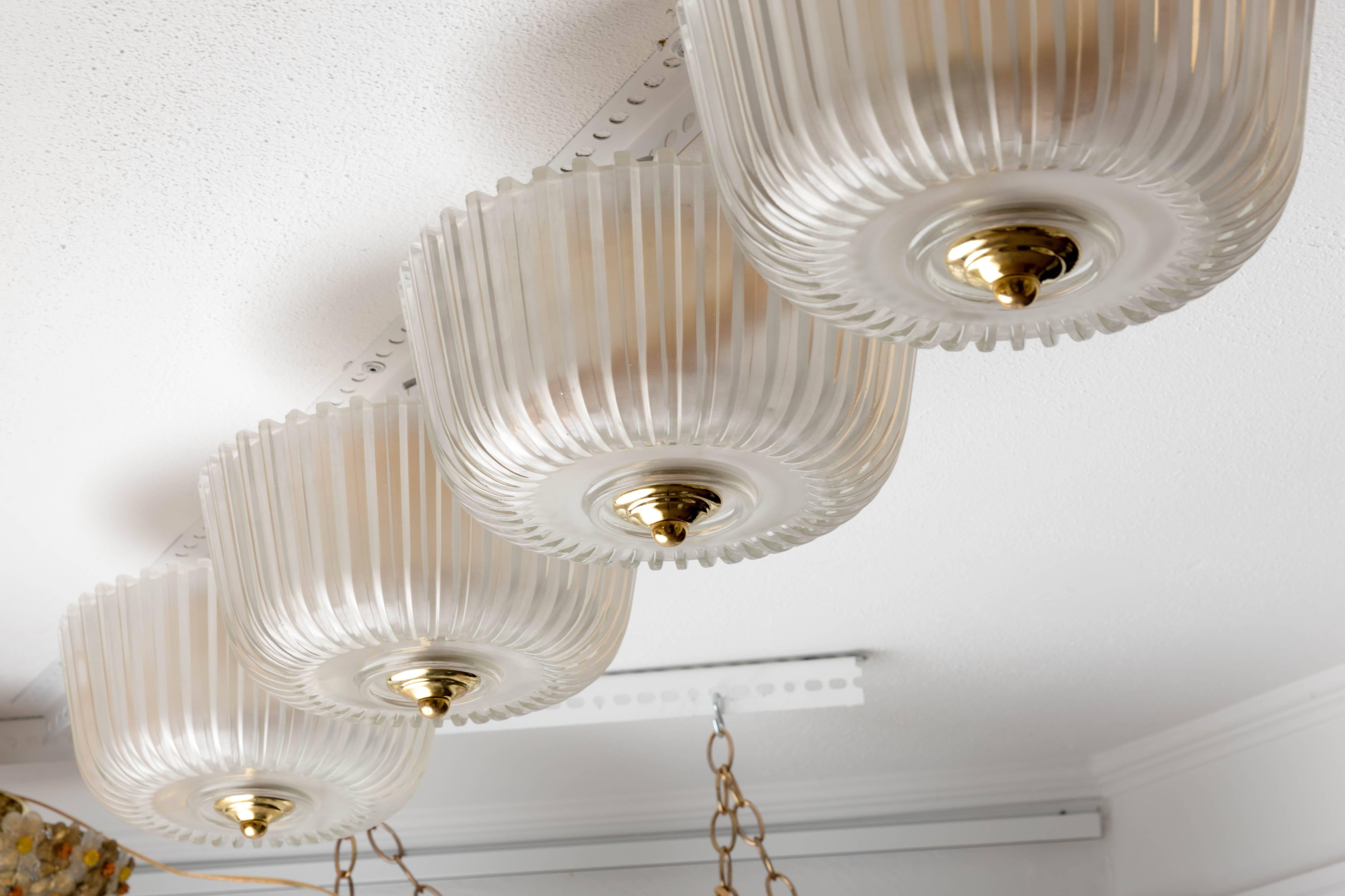 Fluted frosted glass flush mount ceiling fixture with brass detail.