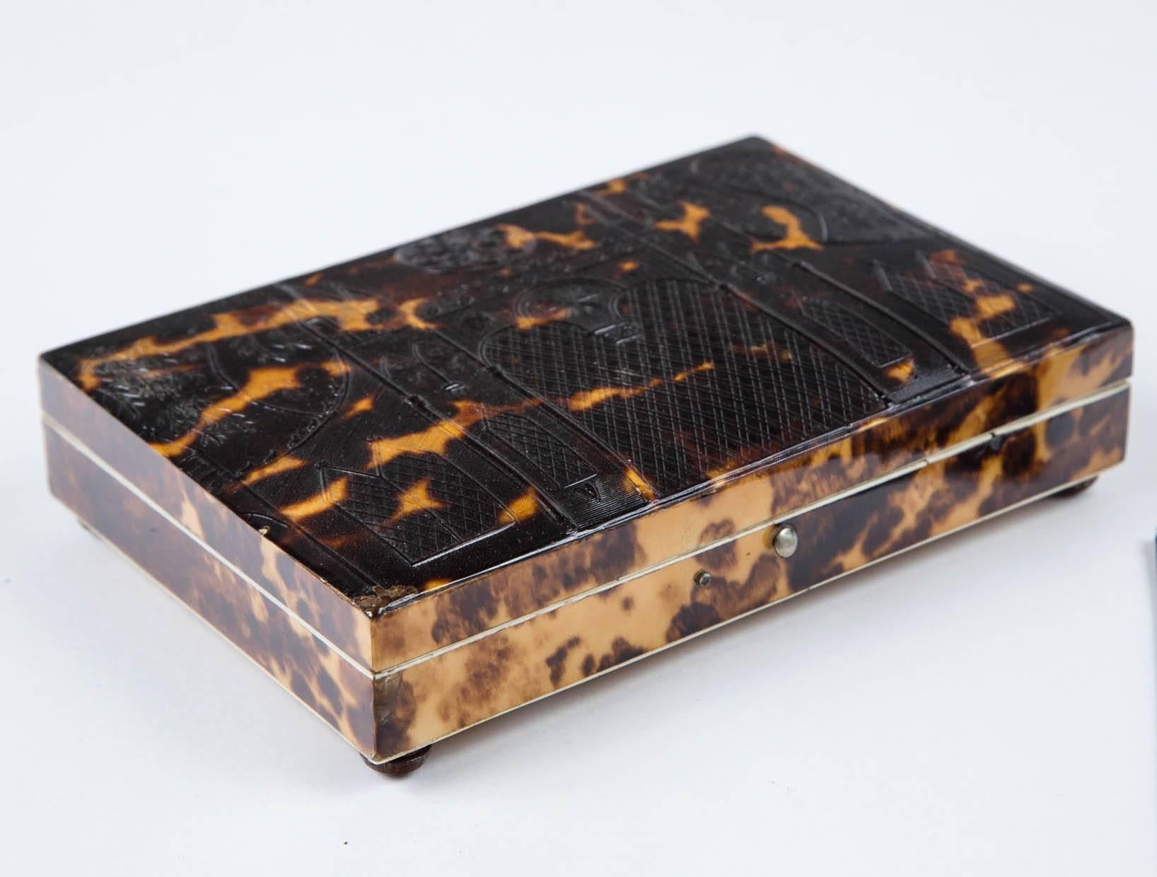 English 1820 tortoiseshell box with a Gothic Look. Excellent condition, and simply fab. Opens and closes perfectly, and has a Navy blue lining inside. The tortoise shell is embossed on the top which looks like a church with stain glass. It has four