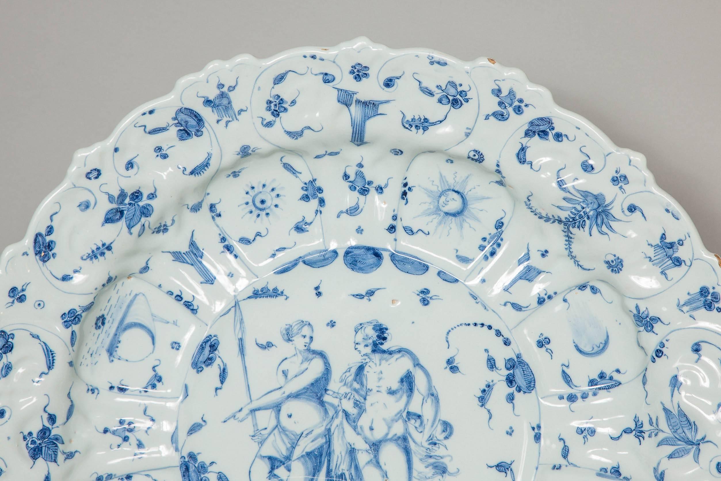 A large and rare Italian Savona blue and white charger dating 1670.
The large shaped plated decorated with so-called "tappezzeria" pattern (meaning wallpaper" and at the centre depicting "Heracles and Omphale"
Only few