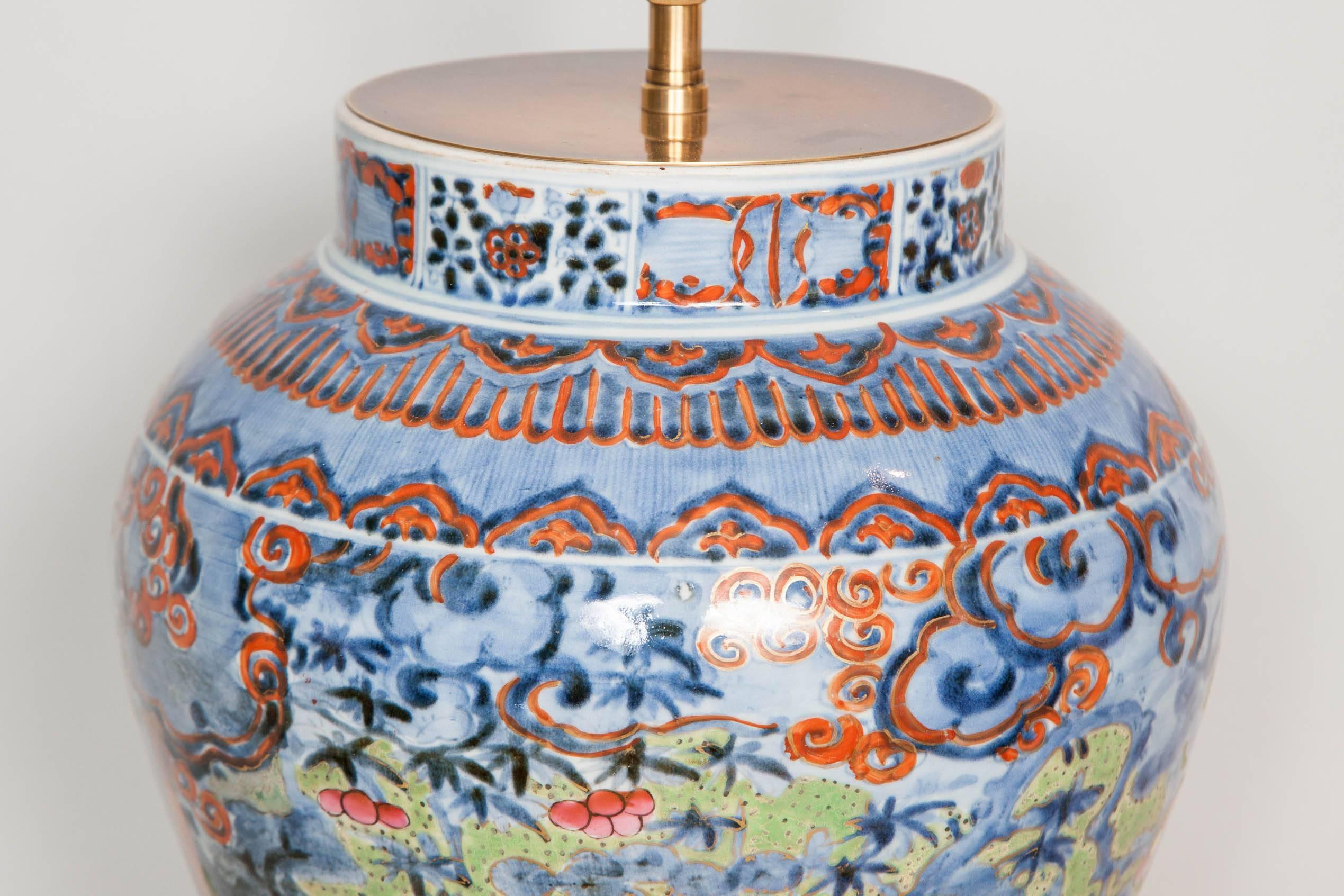 A colourful Japanese Arita vase dating from ca. 1680 which has been clobbered in Europe, possibly in Holland, in the early 18th century.
Now converted into a charming table lamp and fitted with a hand carved and gilt wood base and an antiqued brass