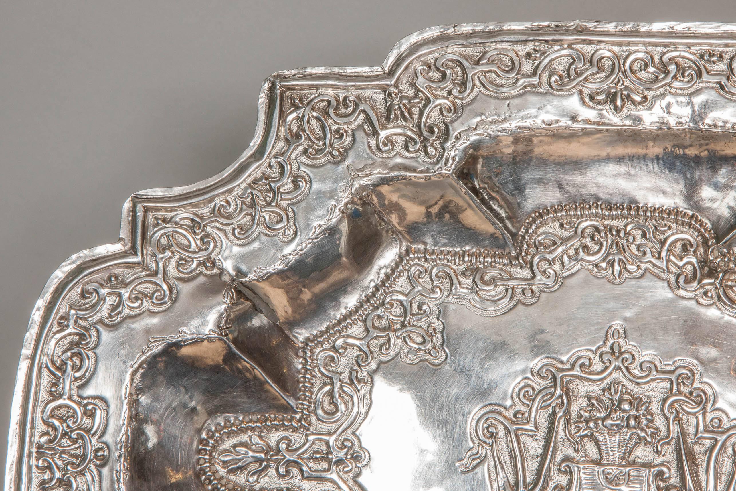 This richly embossed silver tray dates from circa 1650 and it is most probably Dutch; It bears three marks on the lower right corner. it was most probably used as a glove tray. Some wear and soldering restoration to one corner.
Large decorative