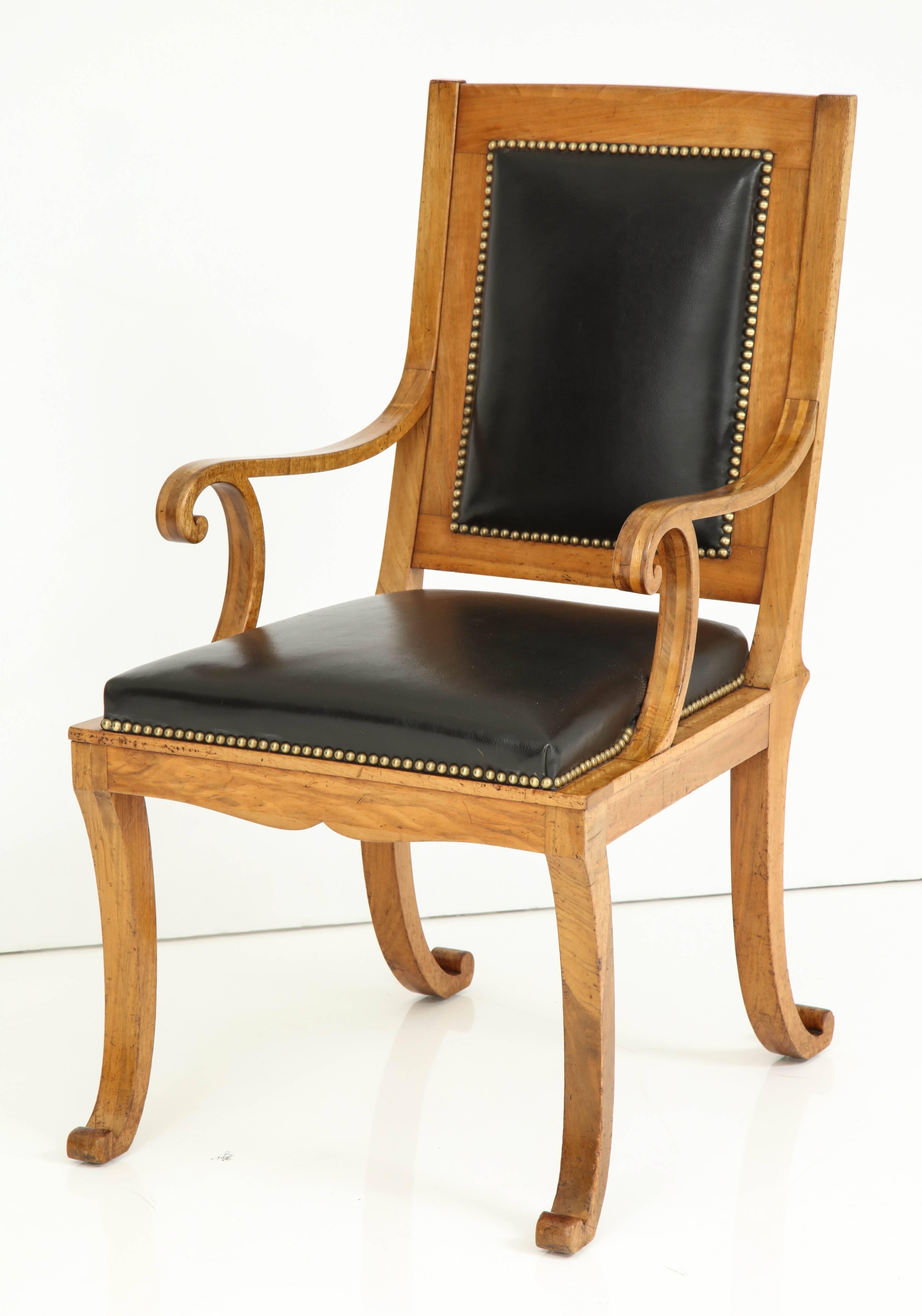 A rare German fruitwood Klismos armchair, circa 1840s with a partially leather padded rectangular backrest, above a leather upholstered seat, scrolled armrests and scrolled supports, raised on four scrolled saber legs.
Interest construction of the