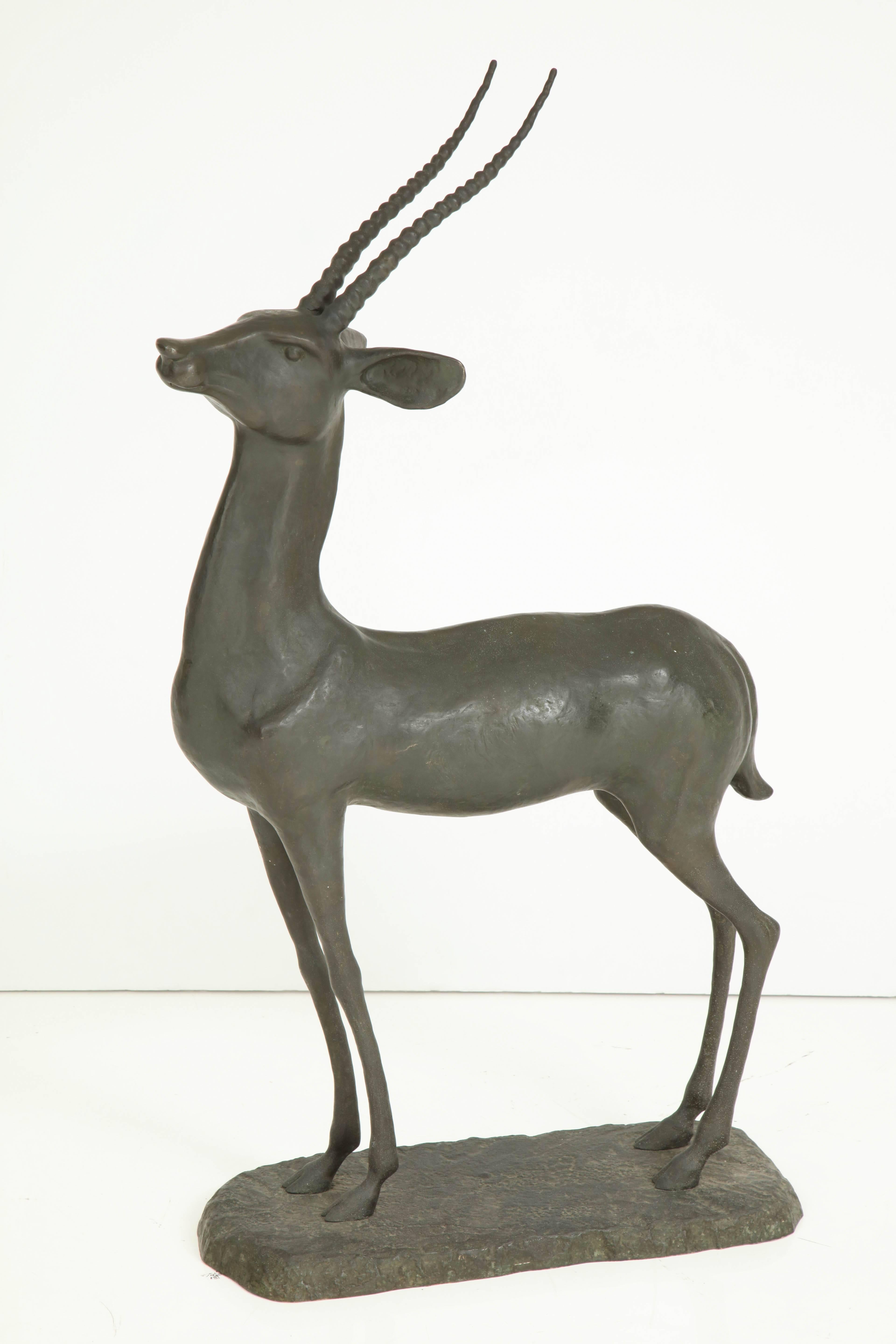 1950s Art Deco style bronze gazelle having alert posture and elegant legs, all standing on a naturalistic base.