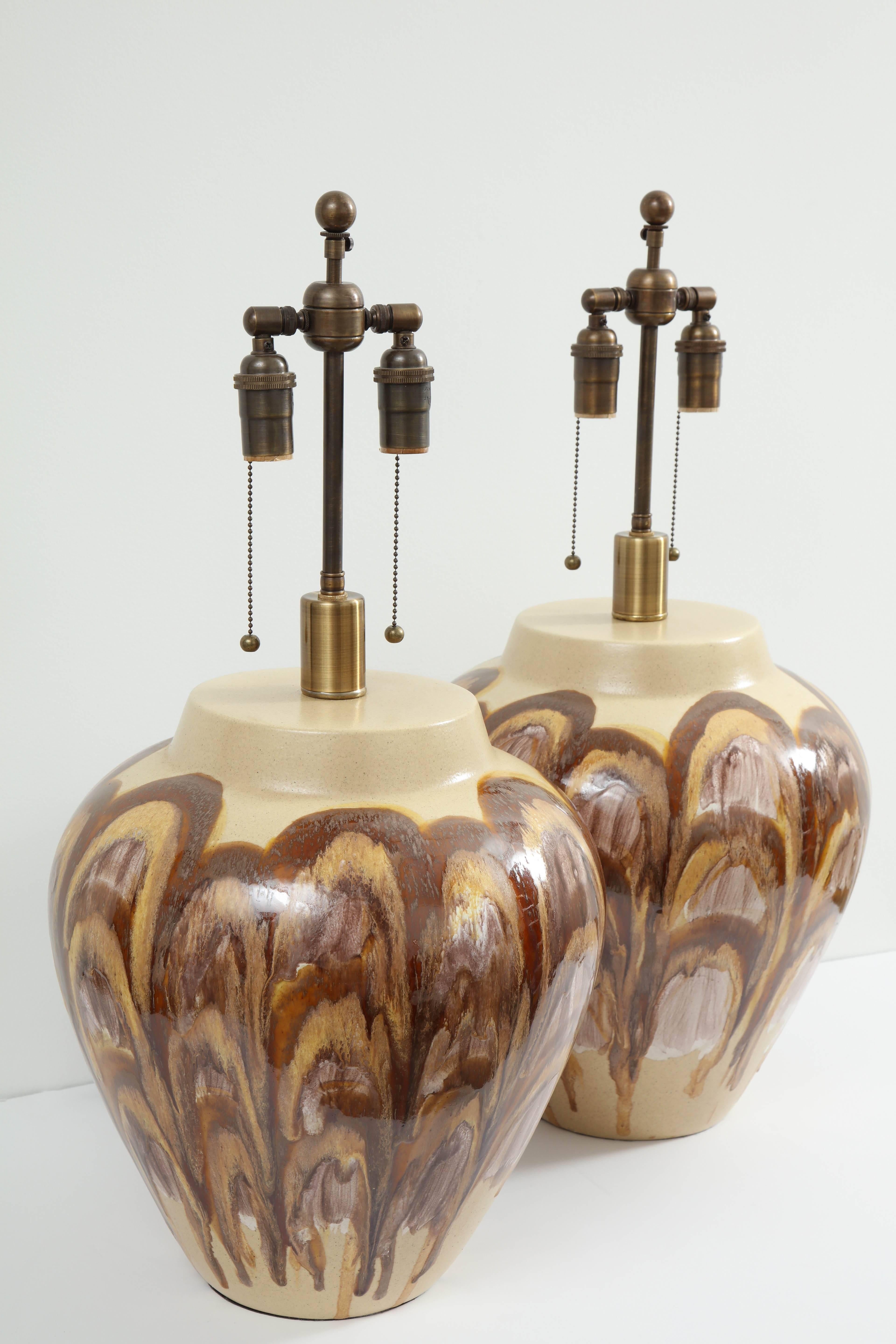Large pair of 1960s ceramic lamps. 
The large lamp bodies have a wonderful earth tone glaze which resembles oyster shells. The lamps have been newly rewired for the US with bronze finished double clusters.
The ceramic portion of the lamp stands at