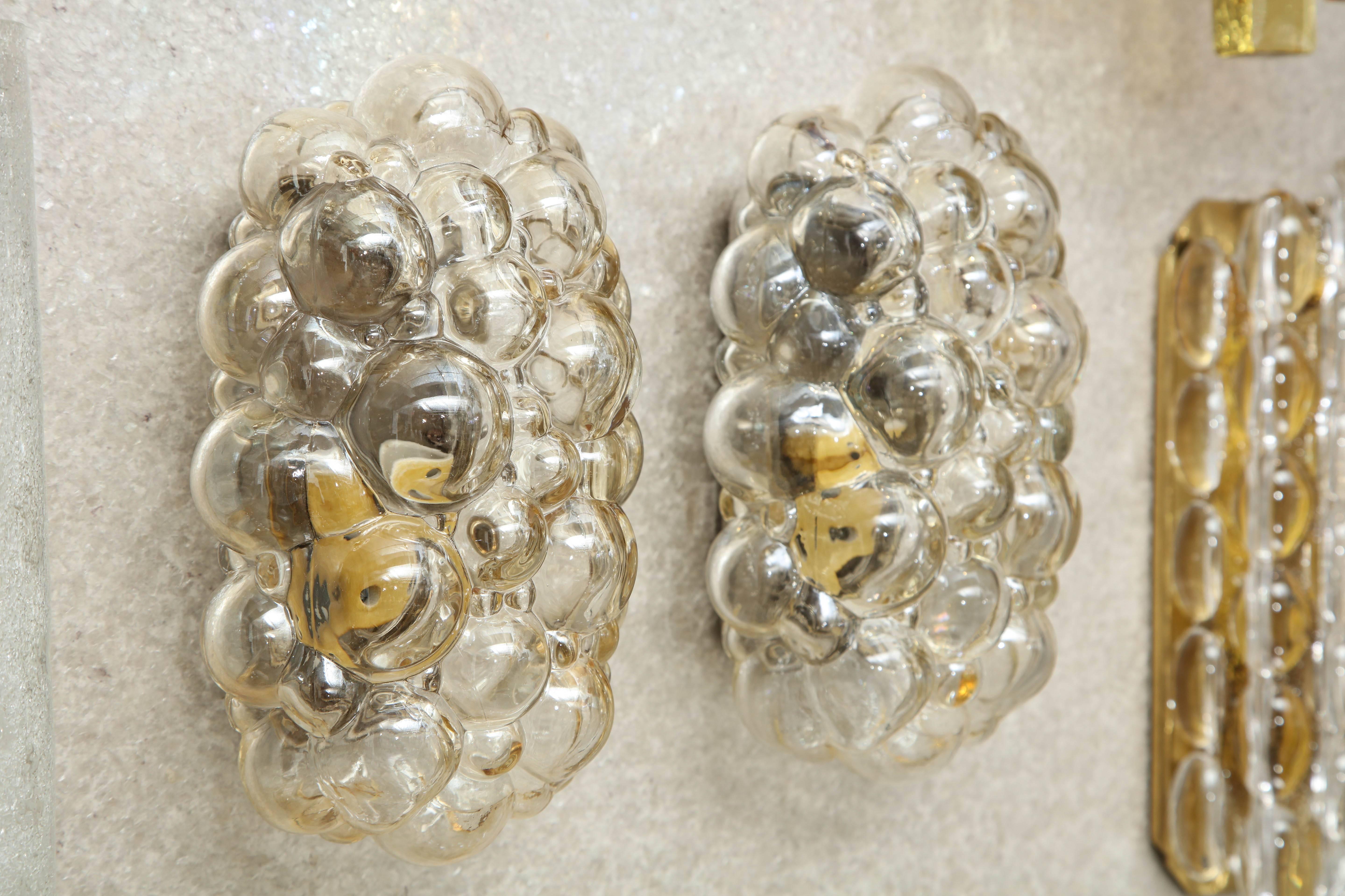 Pair of light amber/champagne colored bubble glass sconces designed by Helena Tynell for Limburg. Each sconce has one light source which uses an Edison type bulb. Rewired for use in the USA.

Currently we have 2 pairs available at 1800/pair.