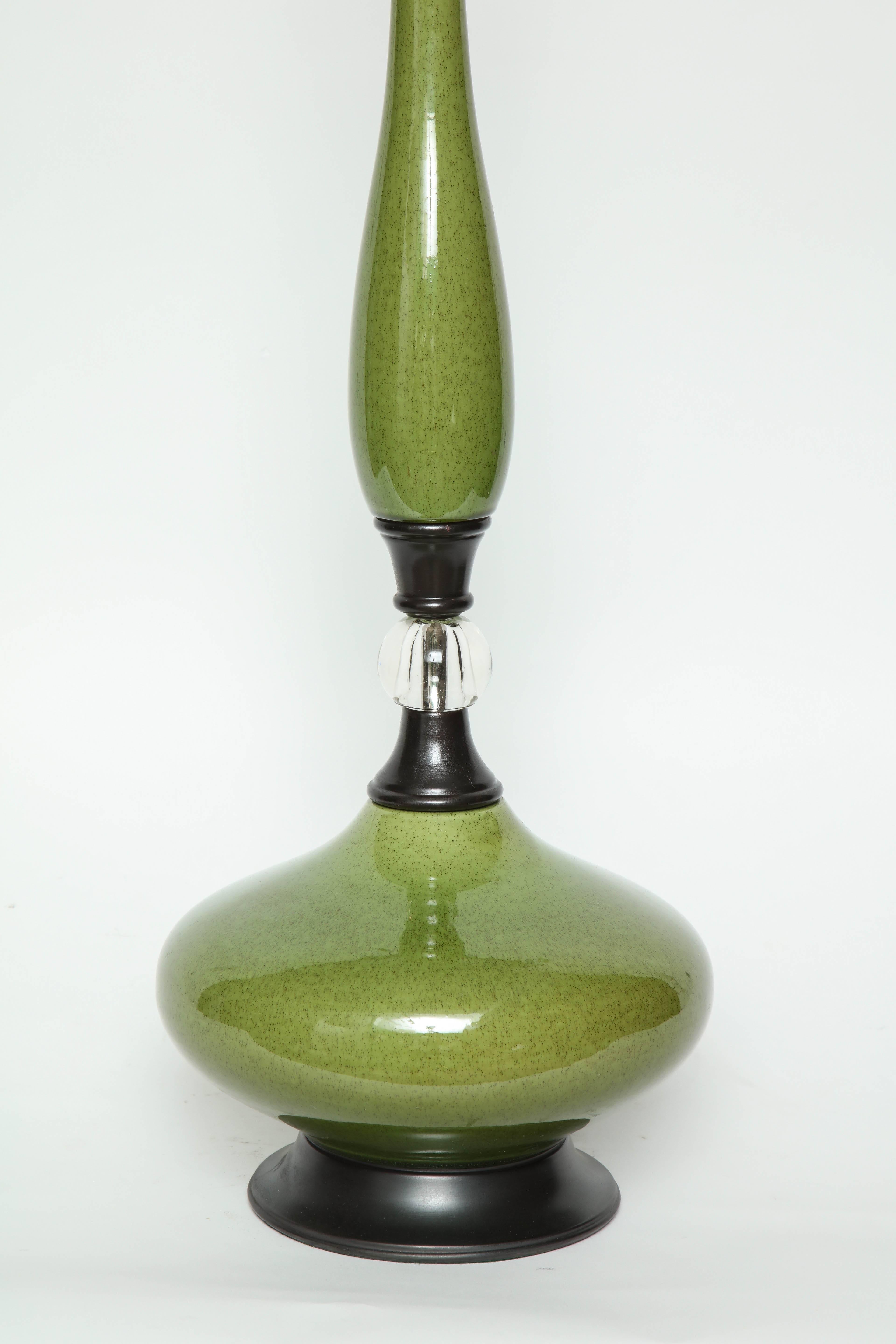 Pair of genie bottle shaped moss green speckled glazed ceramic lamps with dark bronze fittings and a clear glass orb. Lamps have been rewired for use in the USA with brown silk cords.