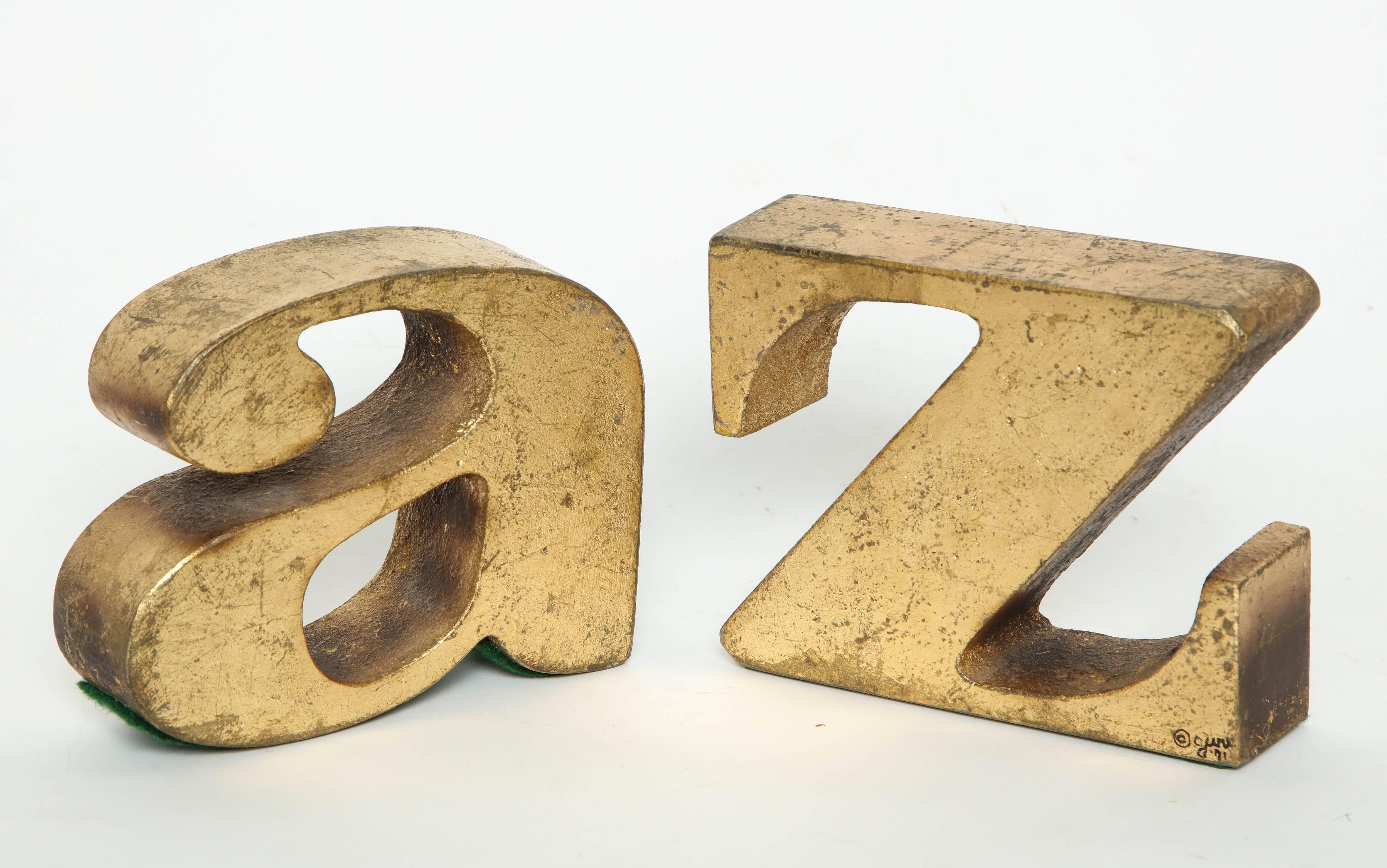 Pair of gilt solid metal A-Z bookends by C Jere for Artisan House, signed.