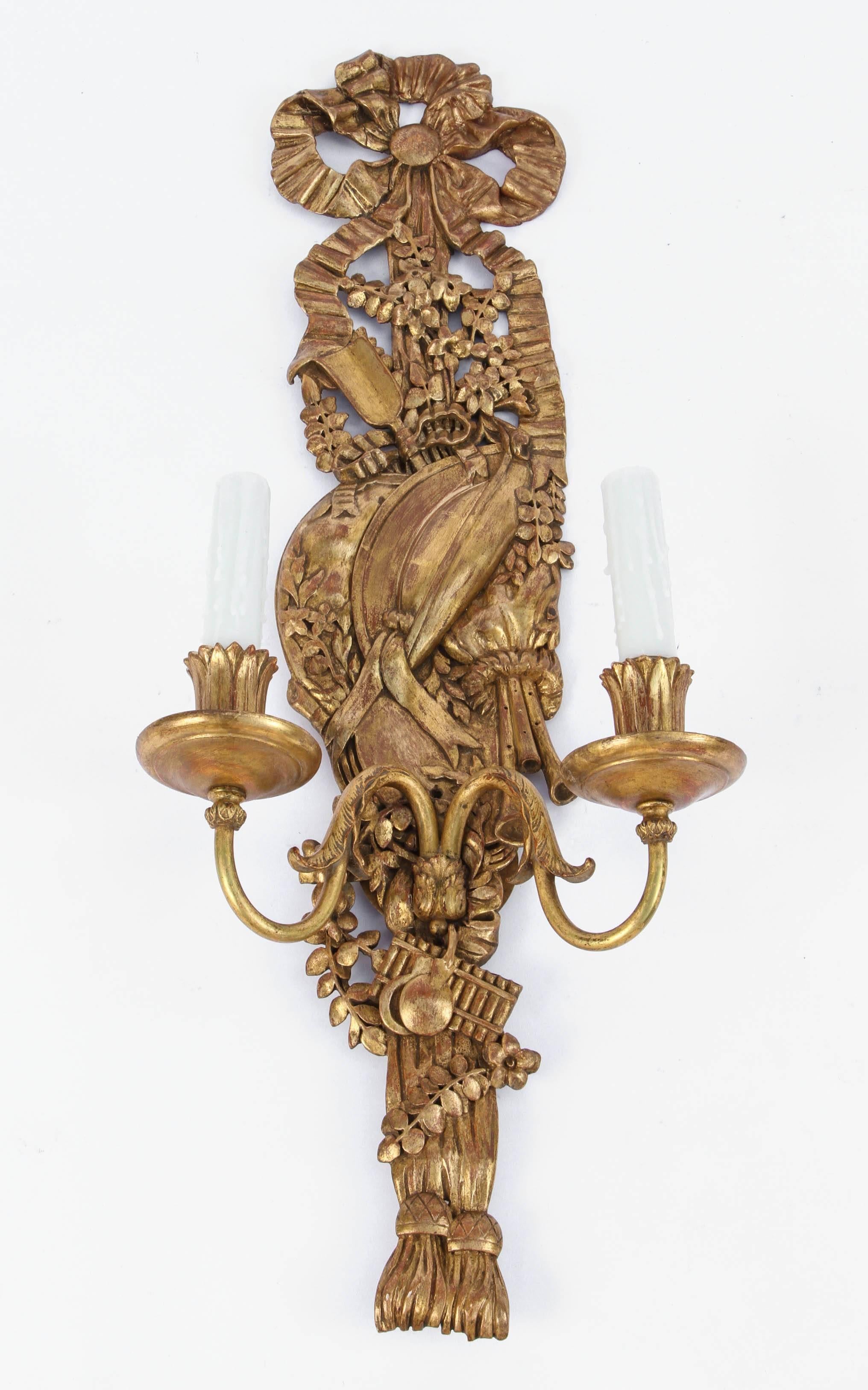 Pair of finely carved Italian giltwood and bronze sconces with bow and tassel motif. The sconces have been newly wired. They are priced as a pair.