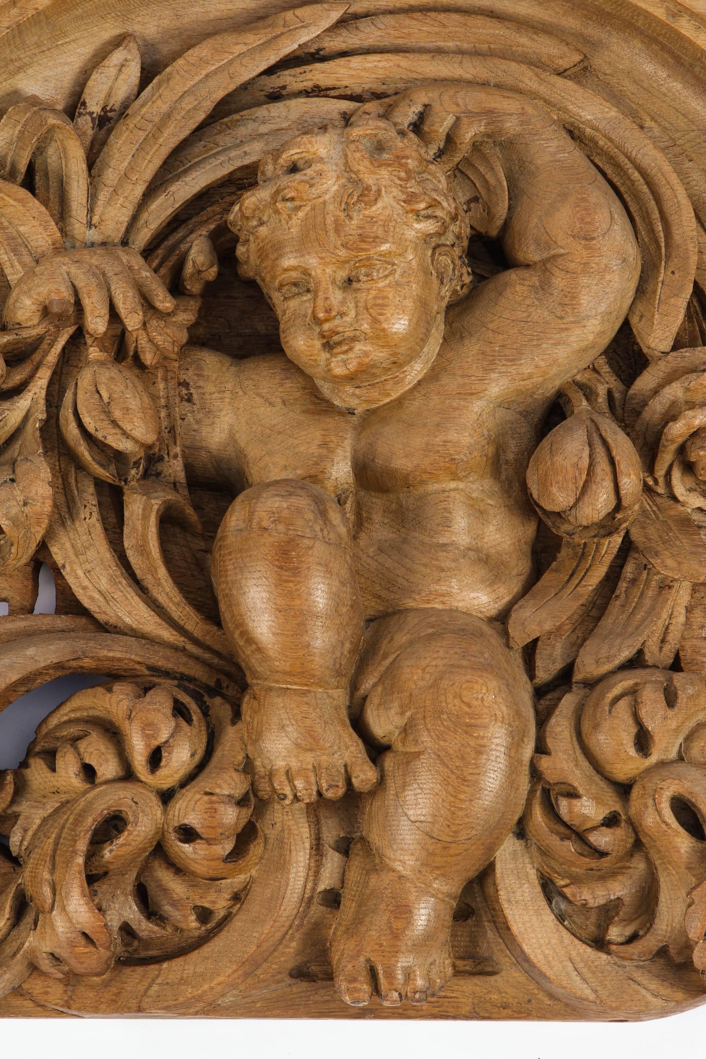 19th century French finely carved oak overdoor with cherub and flower motif.