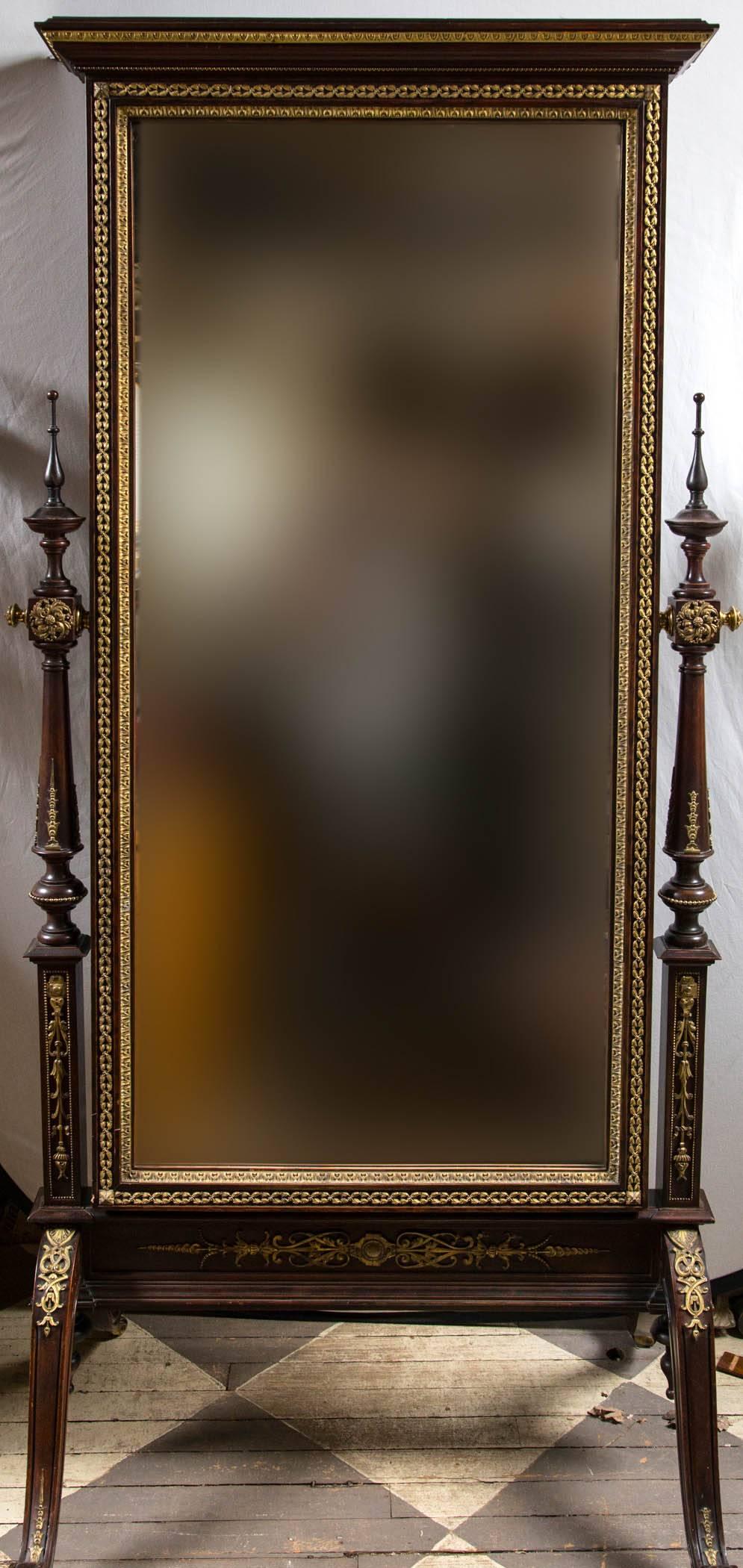 Gilt bronze mounts add to the beauty of this neoclassic style cheval mirror
the glass is bevelled. The mahogany decorated with gilt bronze mounts of fine quality. Scrolling toes, delicate finials on the uprights. On casters.