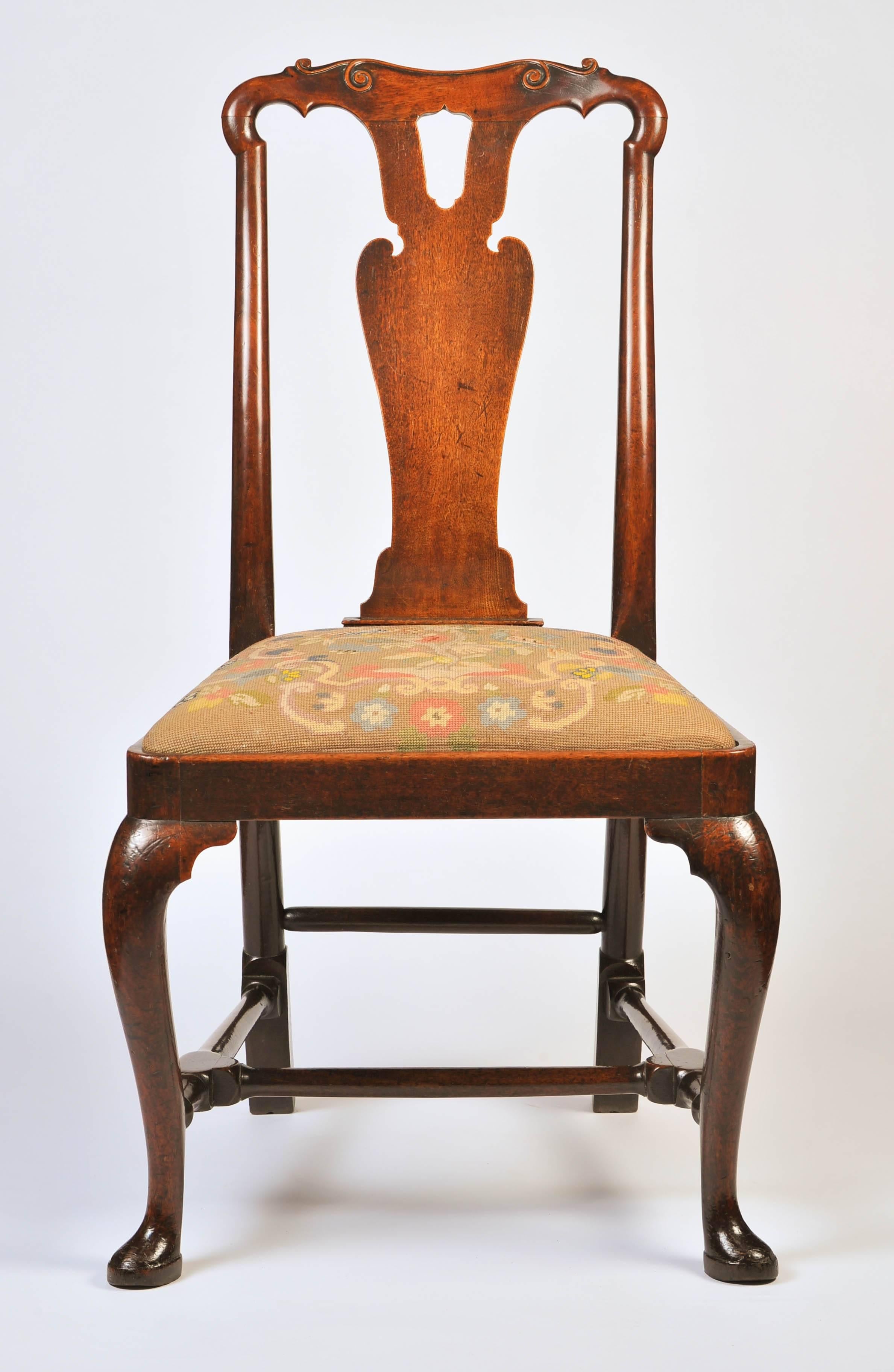 A fabulous pair of early George I period English walnut chairs in the Chinese taste.
The top rail with carved scrolls above a shaped splat back; the drop in seats with contemporary needlework covers over cabriole legs and slipper pad feet to the