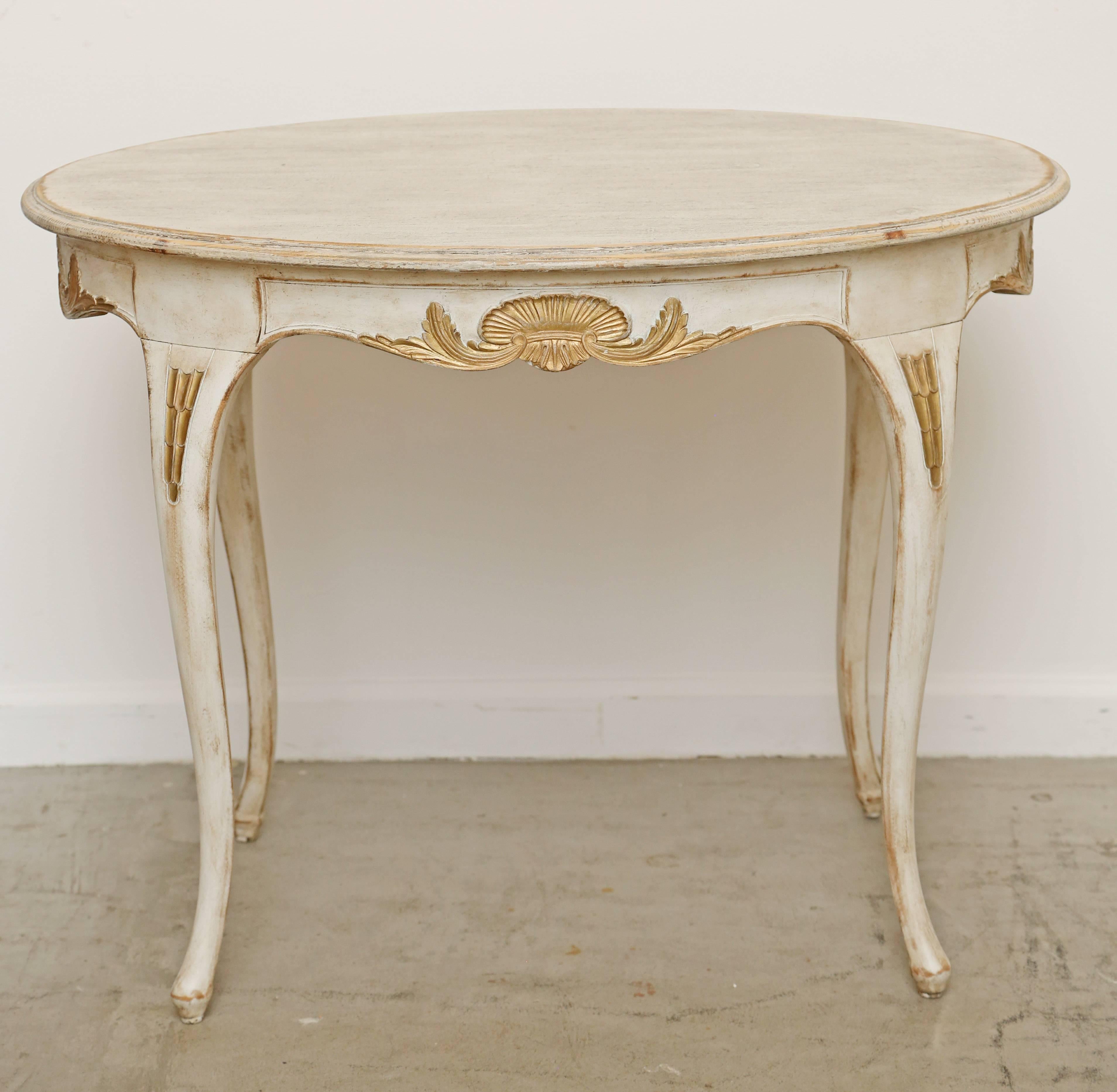 Antique Swedish Rococo carved oval table with elegant carved and gold leaf
 cartouches and details top of each cabriolet legs. The table is a very nice size
oval shape with graceful curved legs and small foot. Could be for a lamp-end
table or a