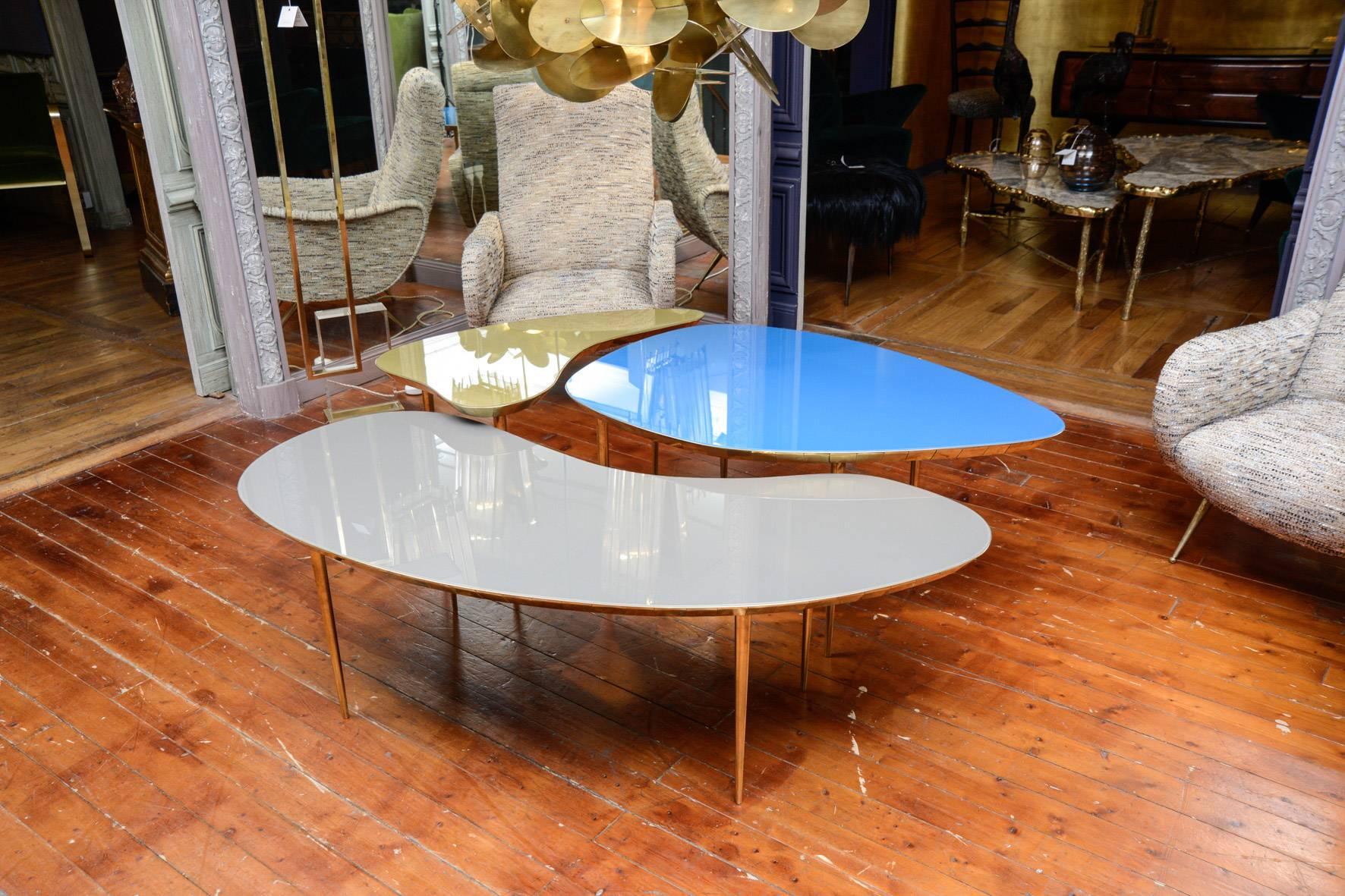 Set of three free shape coffee tables in colored mirrors blue, gold and grey, belt and legs in brass. Collection Gallery Glustin 
Dimensions : 
80 x 40 x H 49 cm
99 x 69 x H 48 cm
130 x 54 x H 43 cm.
 