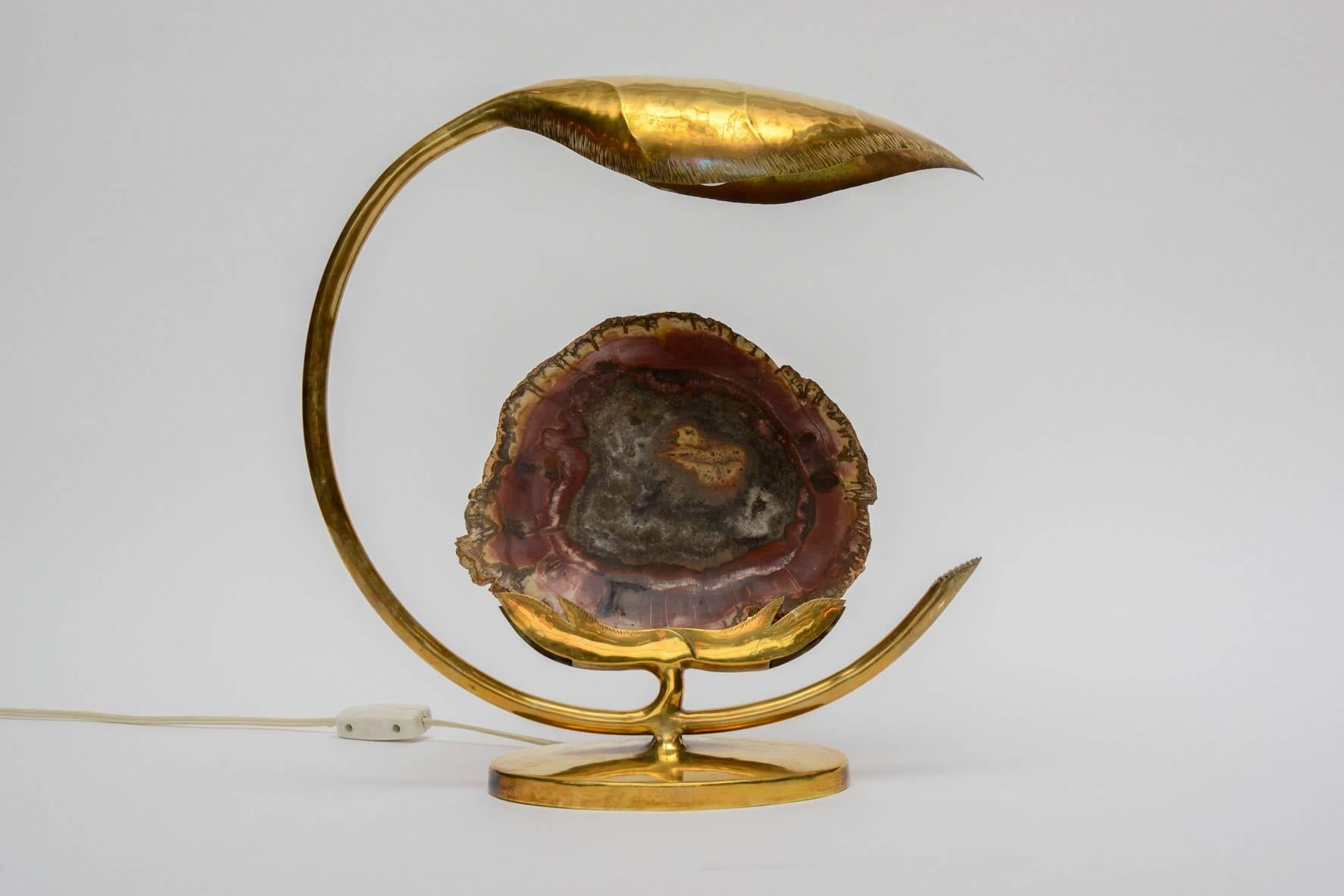 Sculptural table lamp made by the French artist Henri Fernandez in the 1970s.

Slice of polished petrified wood set in brass with a round leaf hiding the bulb.