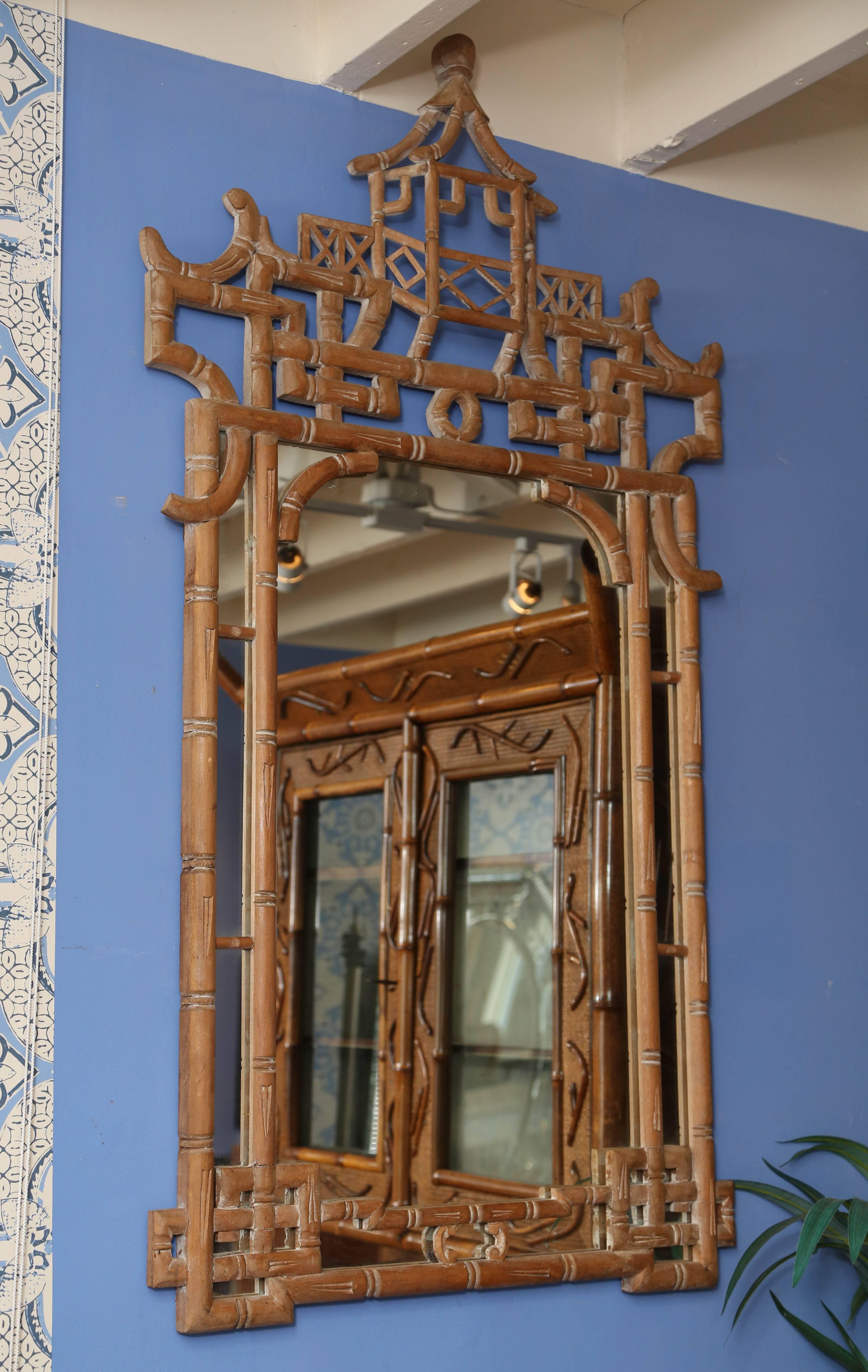 
American, late 20th century. A Hollywood Regency Chinese Chippendale style pickled mirror, having faux bamboo pickled wood frame topped with a pierced pagoda crest with decorative fretwork. Measures: 53", width 29", depth 2".