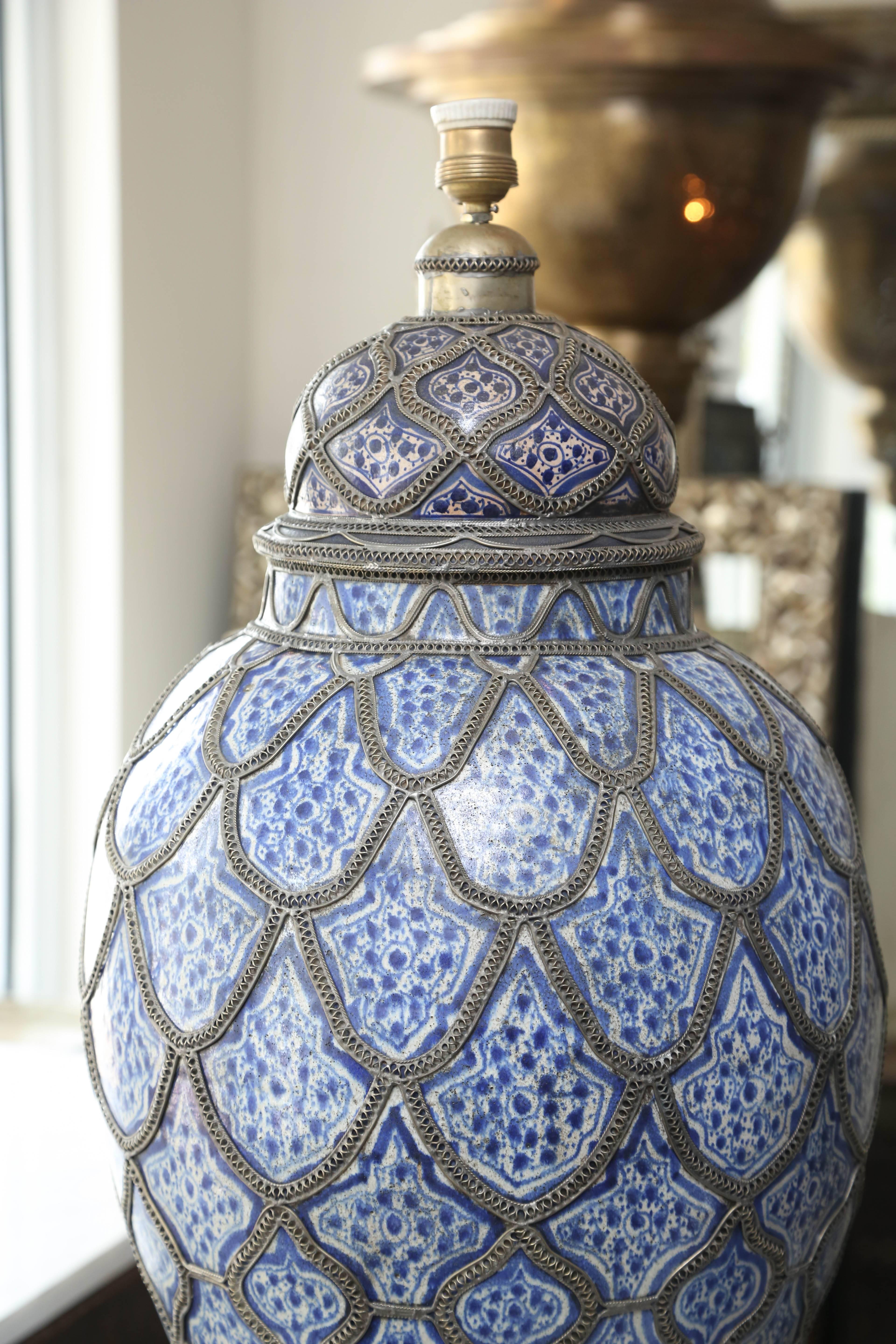 This impressive pair of glazed Fez ceramic ginger jars are crafted in the traditional Moroccan custom and adorned with silver nickel filigree work. They have been converted to 240 volt lamps, and need to be rewired to 120 volts.
Measures: 35