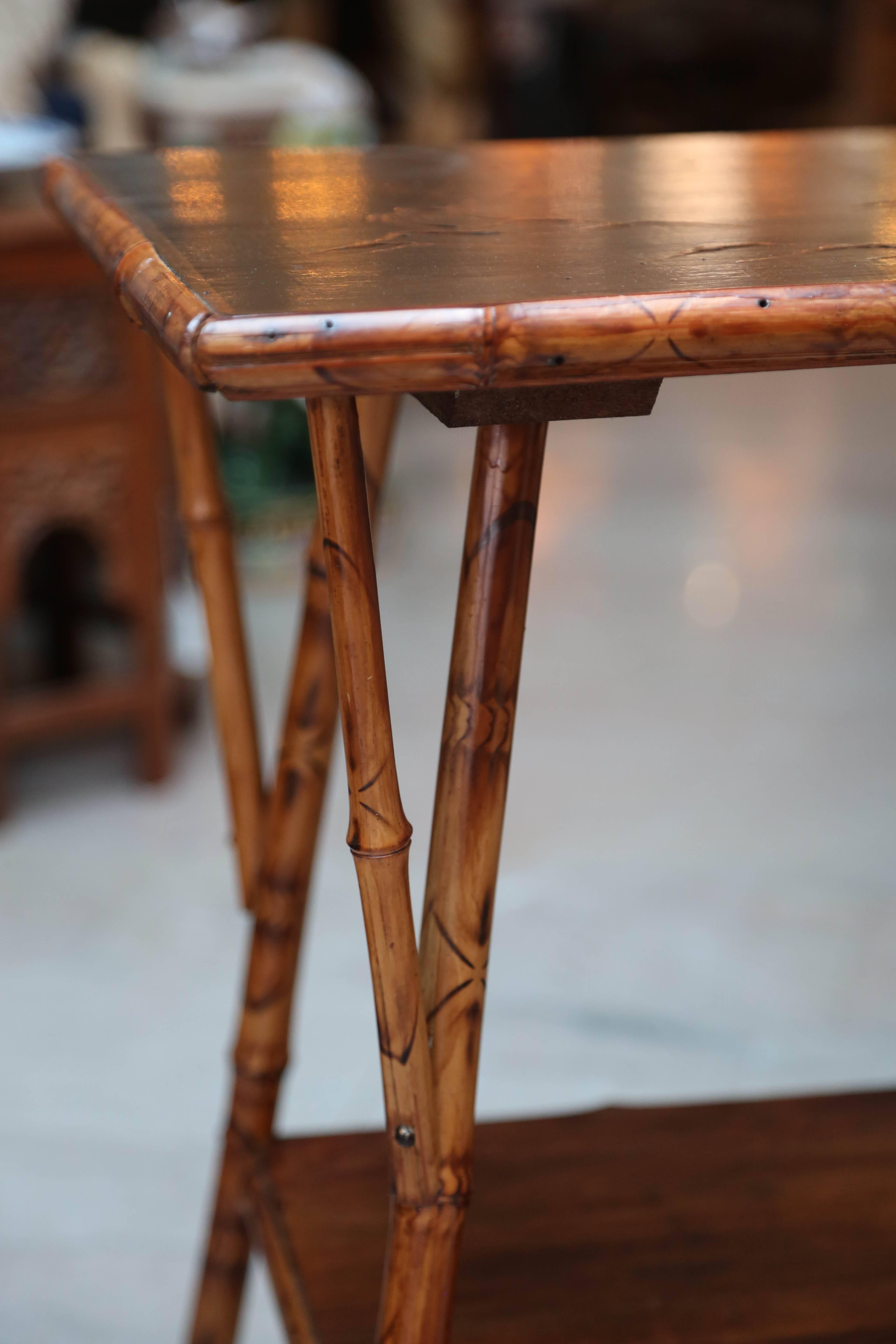 An elegant English burnt bamboo end table signed by the artist Edna Kaylor.
