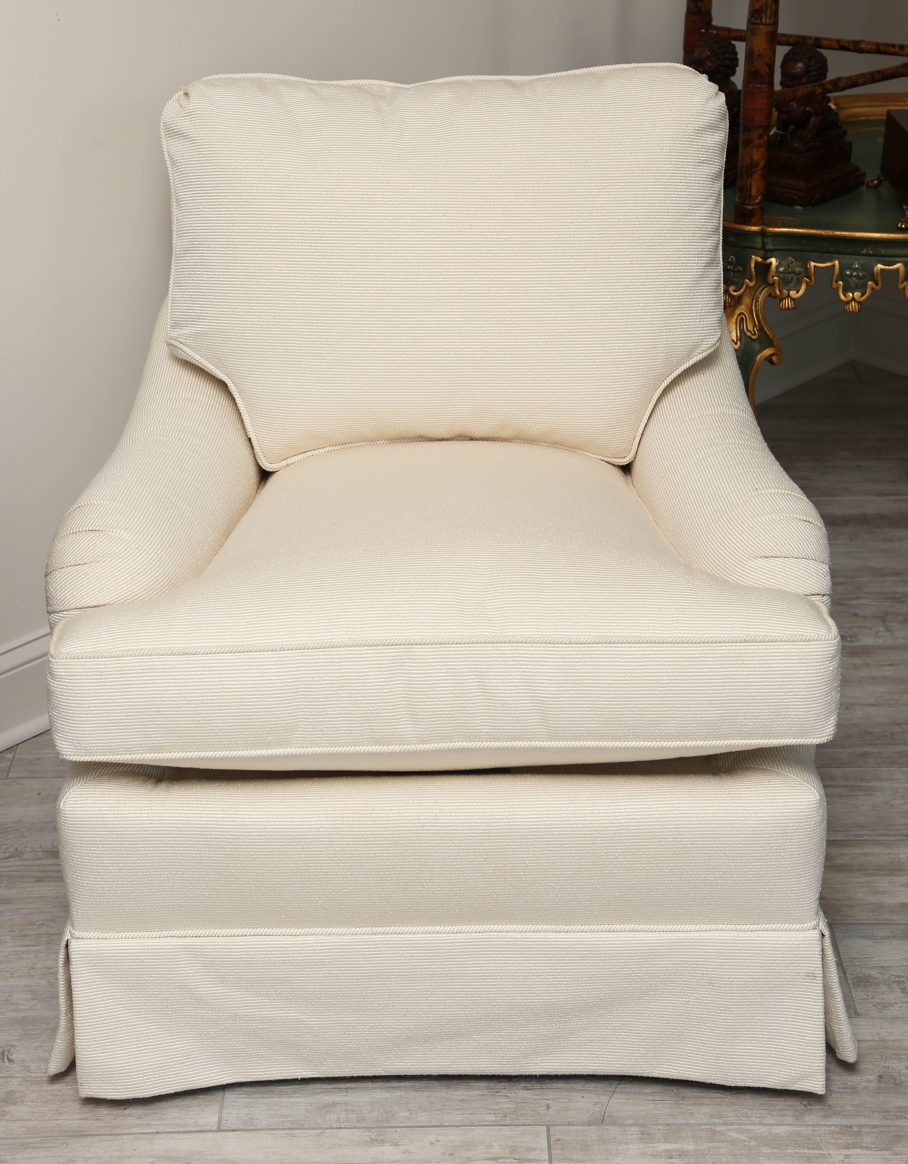 Elegant pair of cream colored upholstered club chairs mounted on a swivel base by Edward Ferrell for Lewis Mittman.