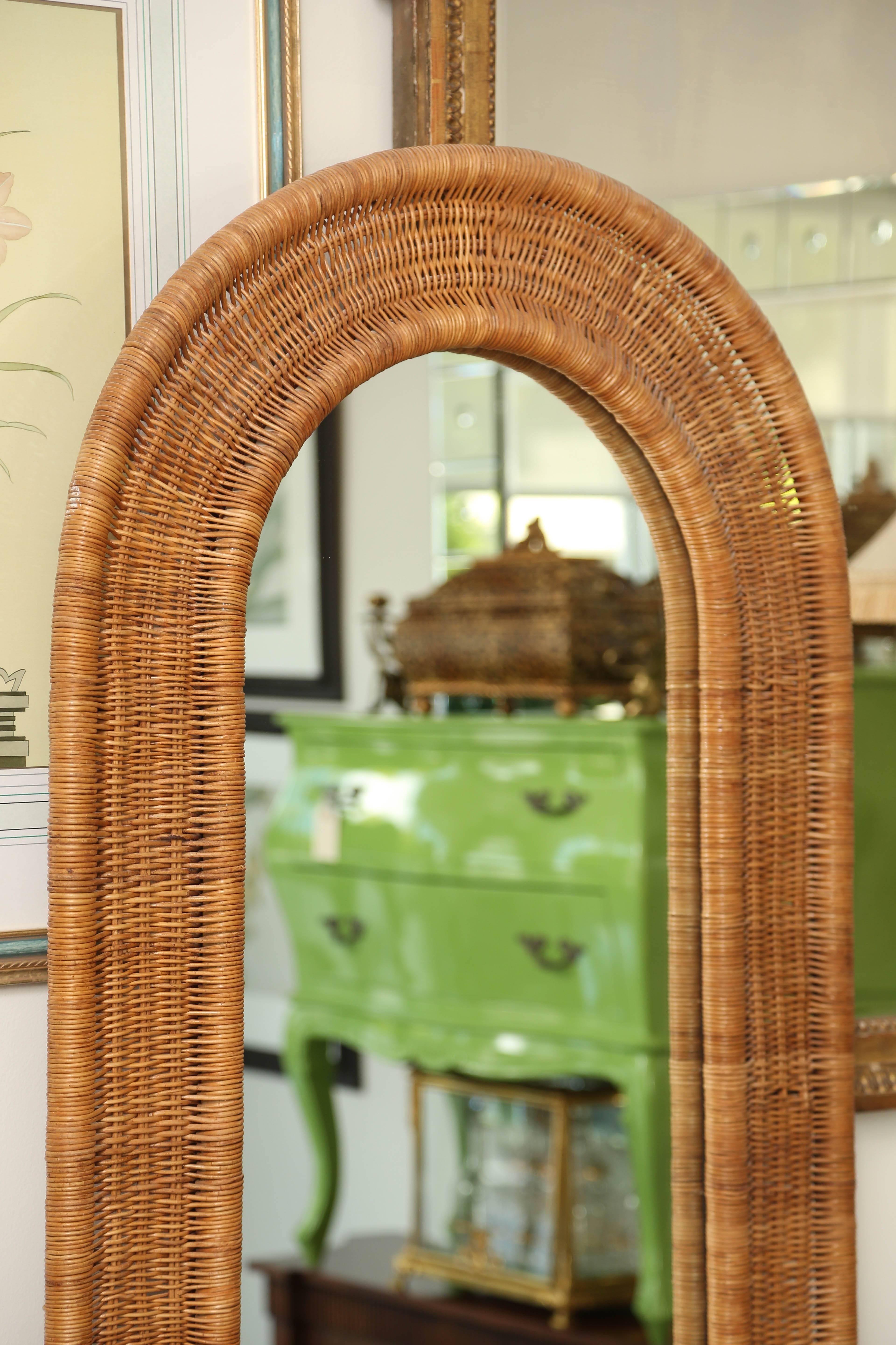 Rattan and mirrored back hall tree with demilune glass shelf.