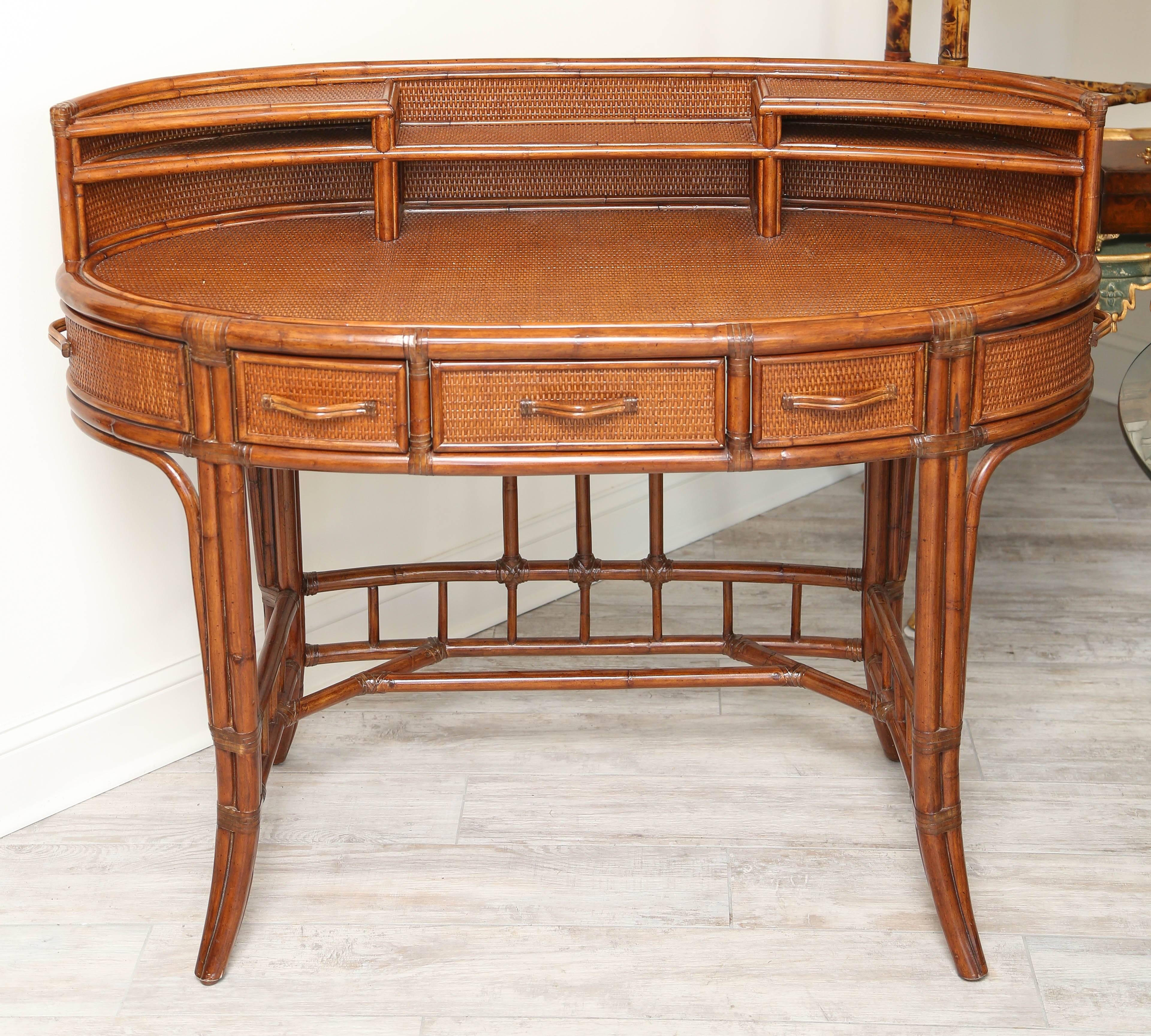 Oval bamboo and rattan desk with multiple drawers and compartments.