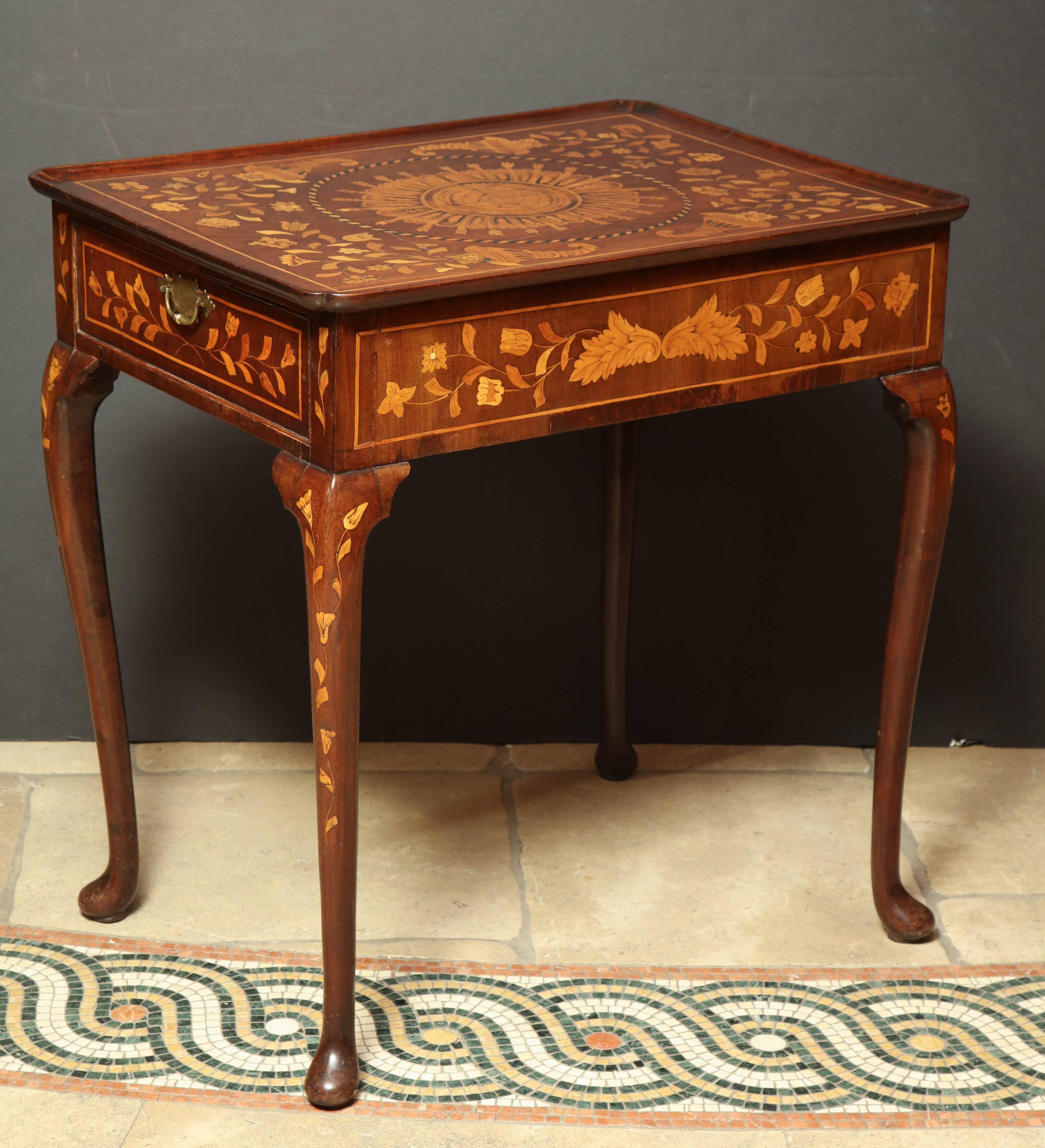 A fine Dutch elaborately inlaid walnut tea table with a carved dish top, single drawer, cabriole legs and pad feet.