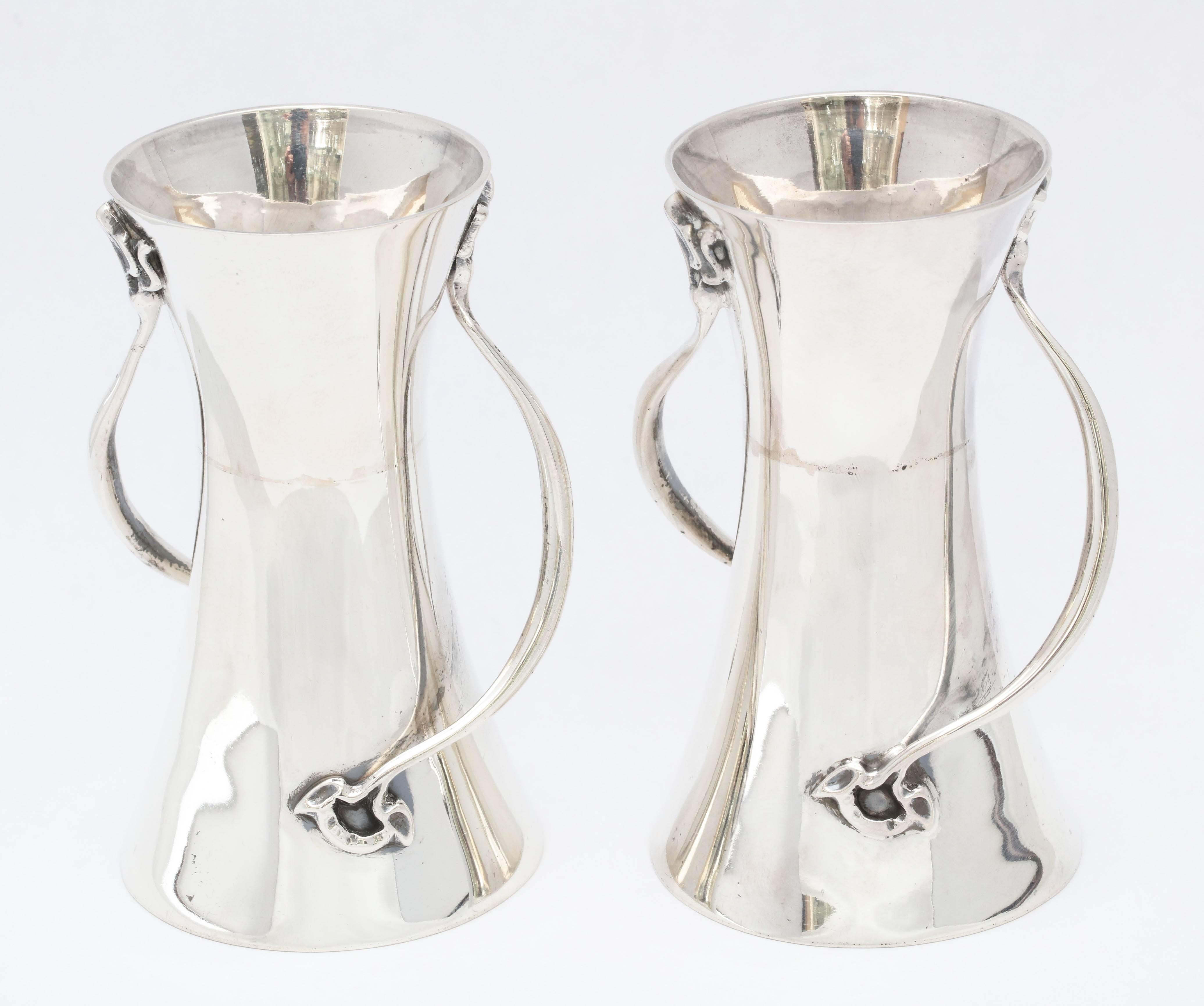 Rare pair of Art Nouveau, sterling silver bud vases, made in the city of Sheffield, England, 1906, George Wish, Ltd. - maker. Handles in the form of flower stems whip around each vase, each handle ending in a flower on the lower portion of the vase.