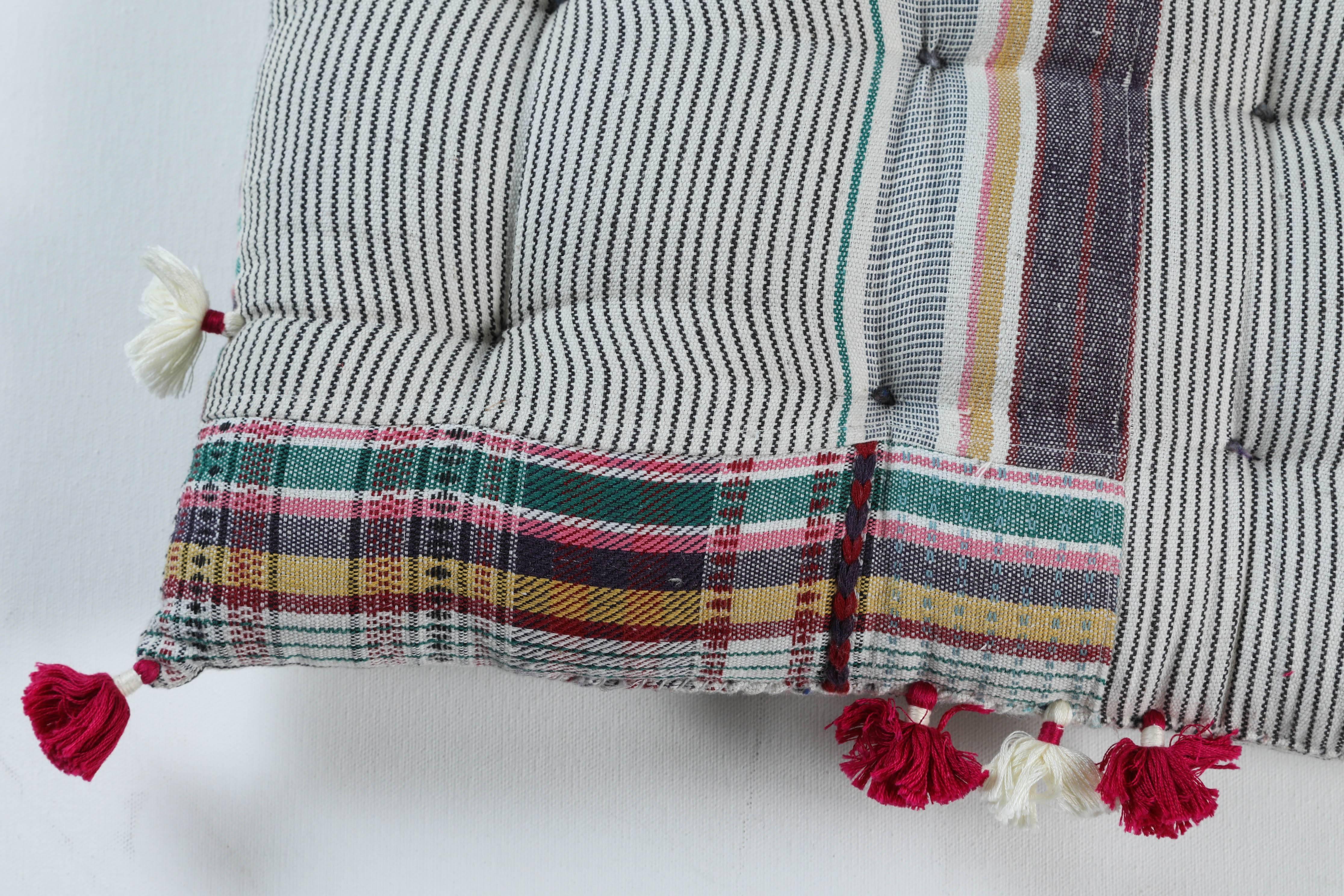 Kala naturally dyed organic cotton from Gujarat, India. Hand loomed using traditional Indian textile techniques to produce extra weft woven stripes and plaids. This multicolor striped pillow has added hand-knotted royal tassels.