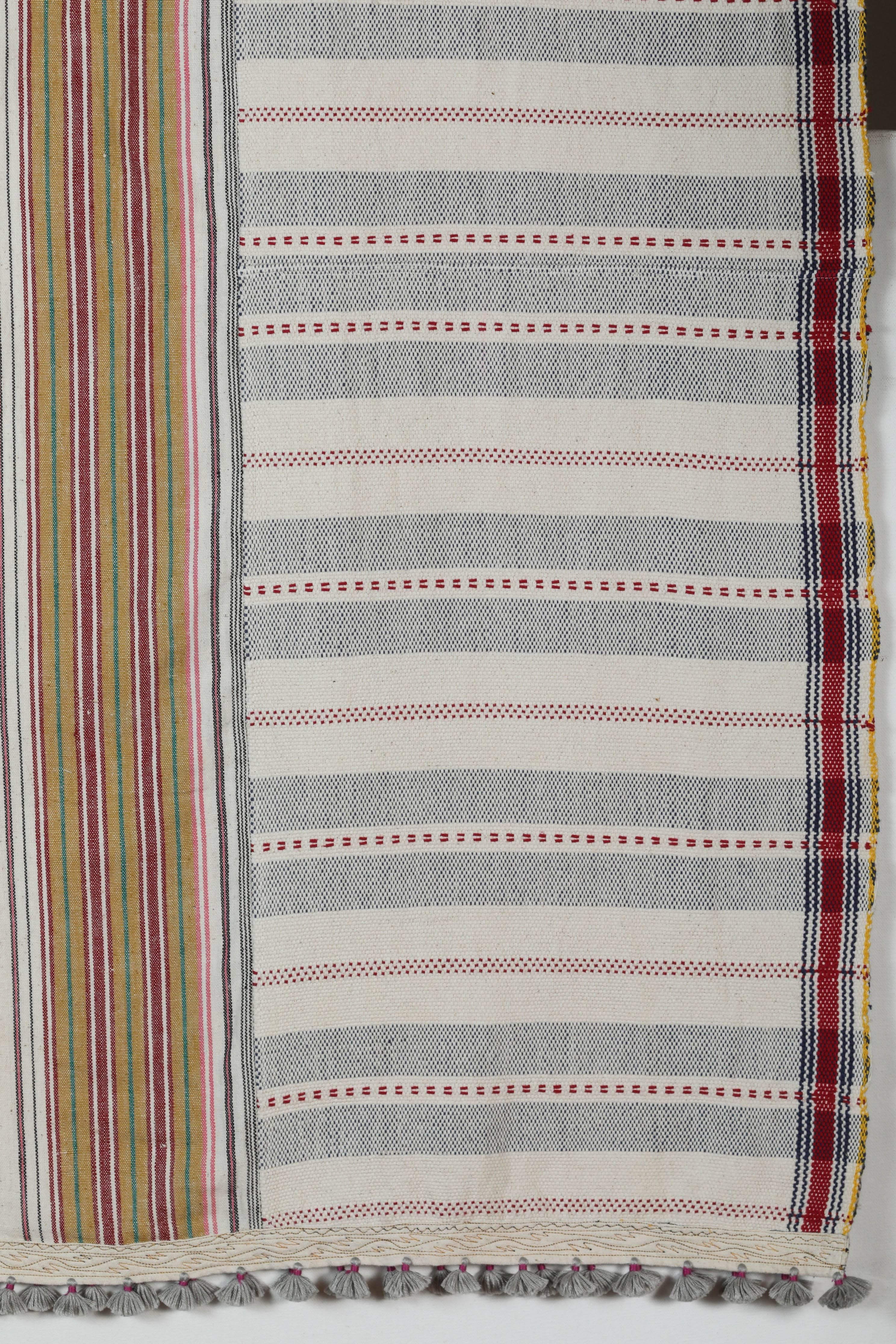 Kala naturally dyed organic cotton from Gujarat, India. Hand-loomed using traditional Indian textile techniques to produce extra weft woven stripes and plaids. This ivory, blue, red and yellow bedcover has added hand-knotted tassels and areas of