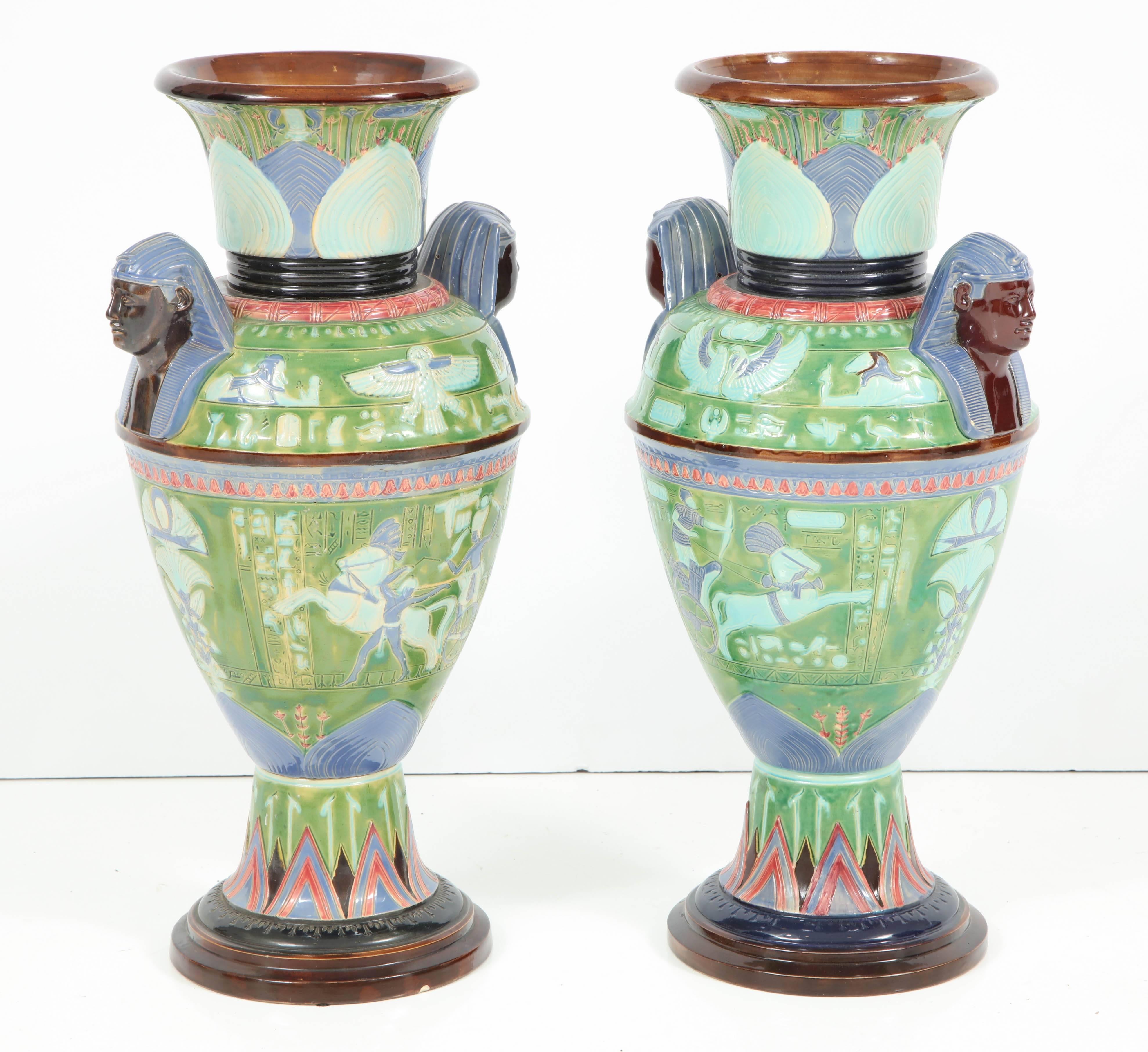 These vases are noteworthy for their form, detailing and spectacular color. With an urn shape, each vase depicts a battle scene on lower portion and images of deities and other Egyptian motifs on upper portion, with two pharaohs flanking the sides.