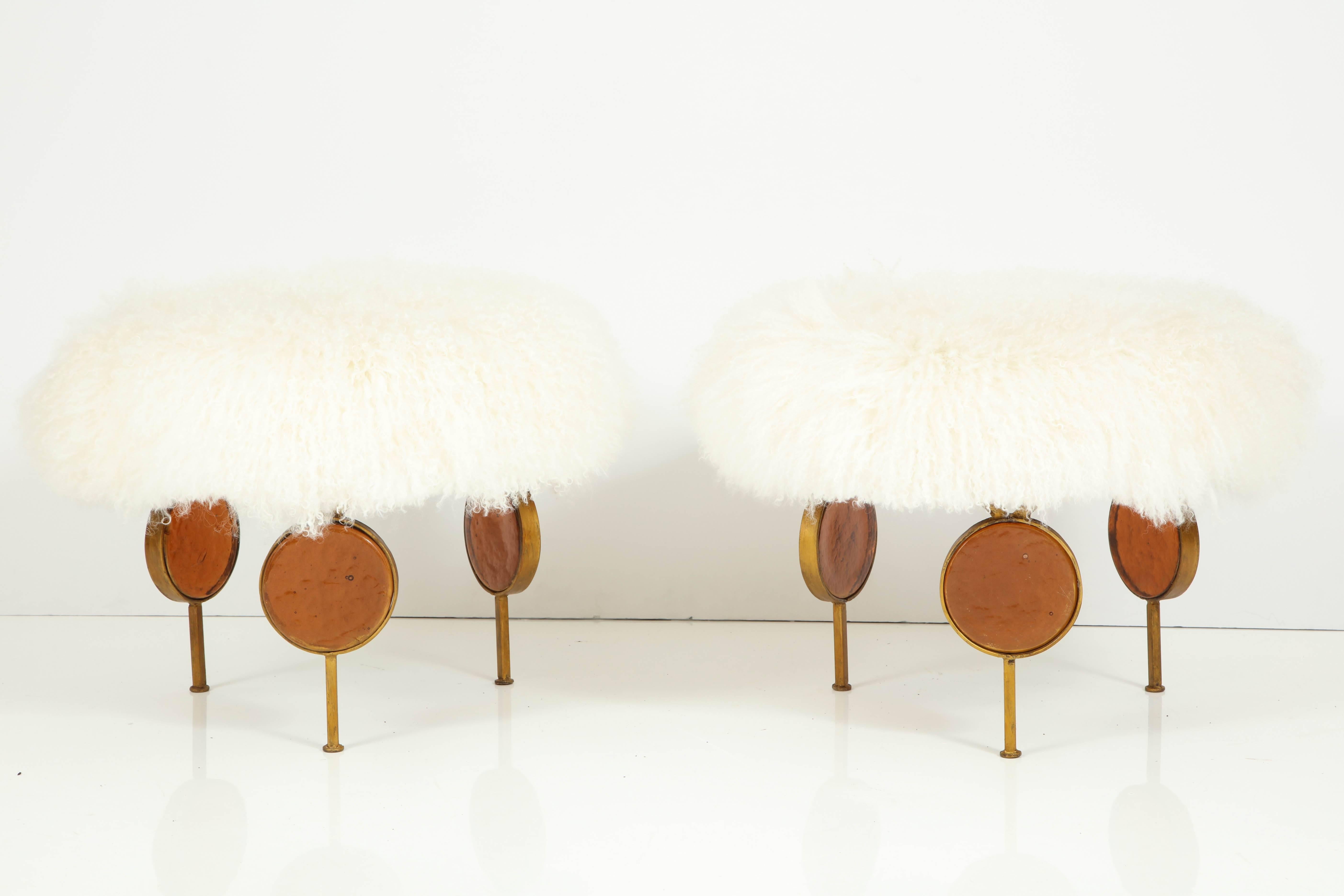Uphostered in Mongolian lamb, the stools are made of wrought iron, gilt and feature 6