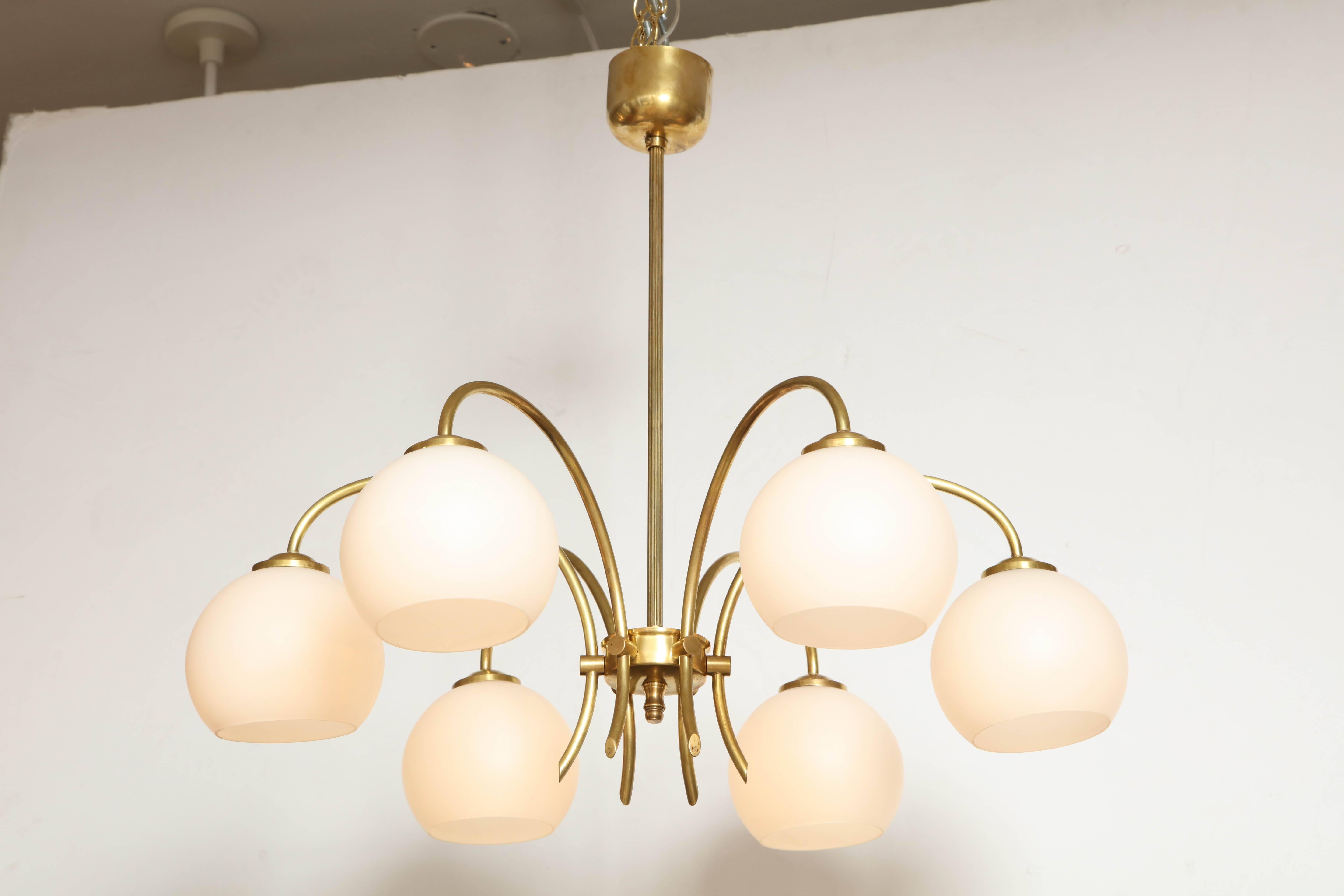 Danish six arched arm brass and milk glass chandelier, circa 1960s. A single reeded stem issuing six scrolled arms with rounded milk glass shades. Rewired for the US 6 x 60watts max.

Probably made by Fog & Mørup

 