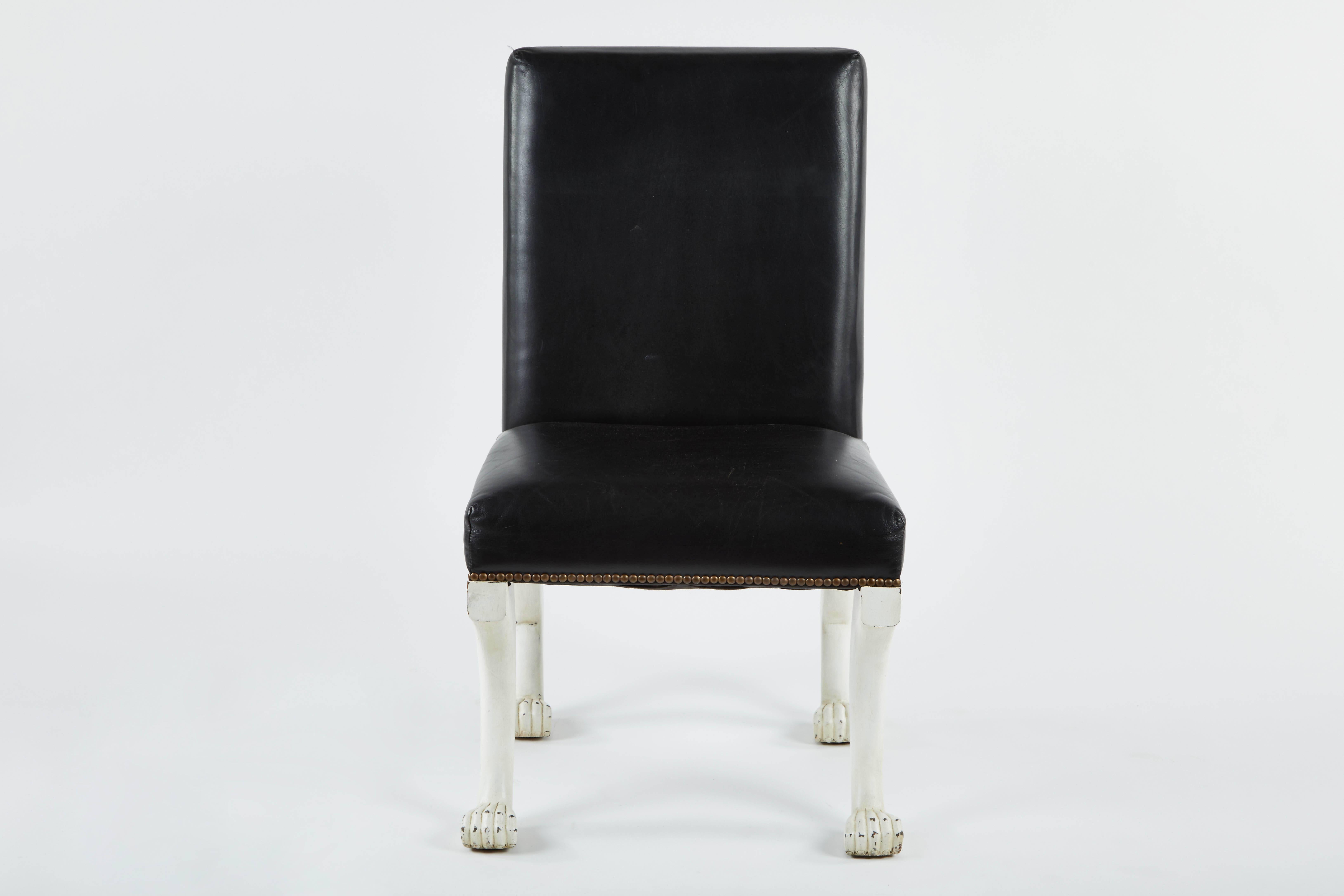 A pair of English painted chairs with paw feet, black leather seat and brass nailhead detail around the back. In the style of John Dickinson's Etruscan chair, from the Pasadena Antiques Market.
