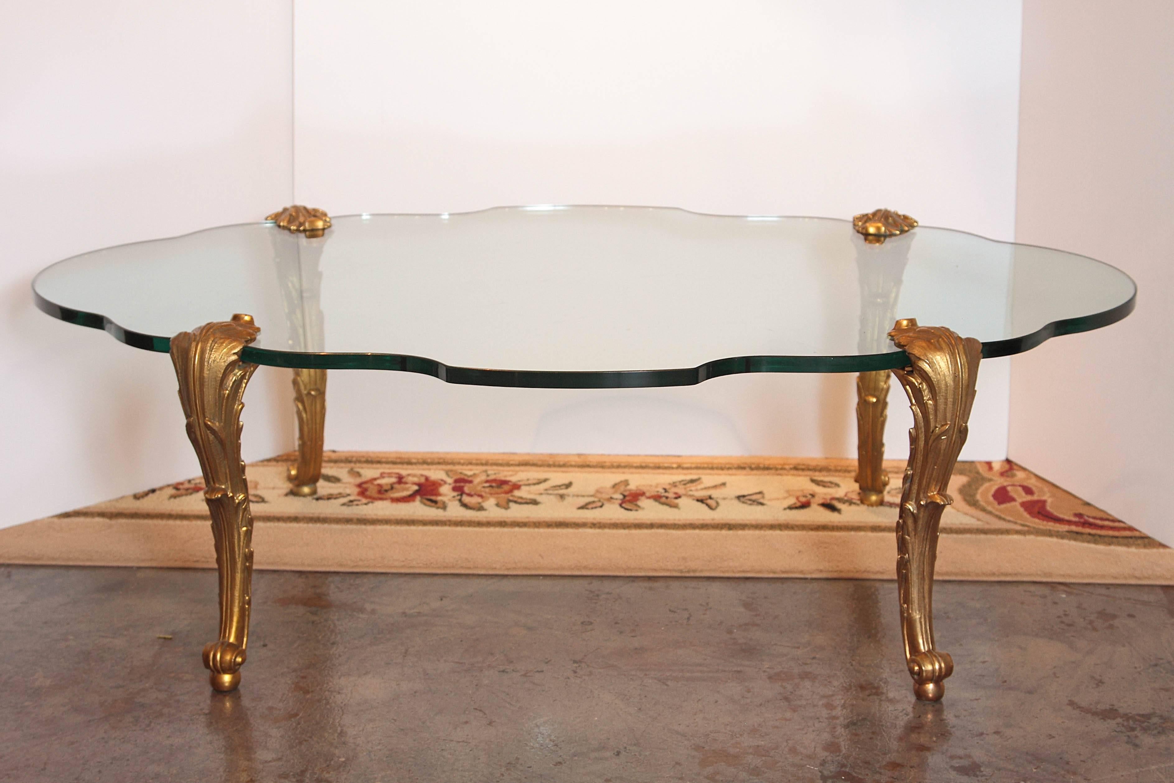Mid-20th century French Louis XV gilt bronze four-legged glass top cocktail table. The legs signed P.E.Guerin. The table sales for $12,000.00 net from P.E.Guerin today.