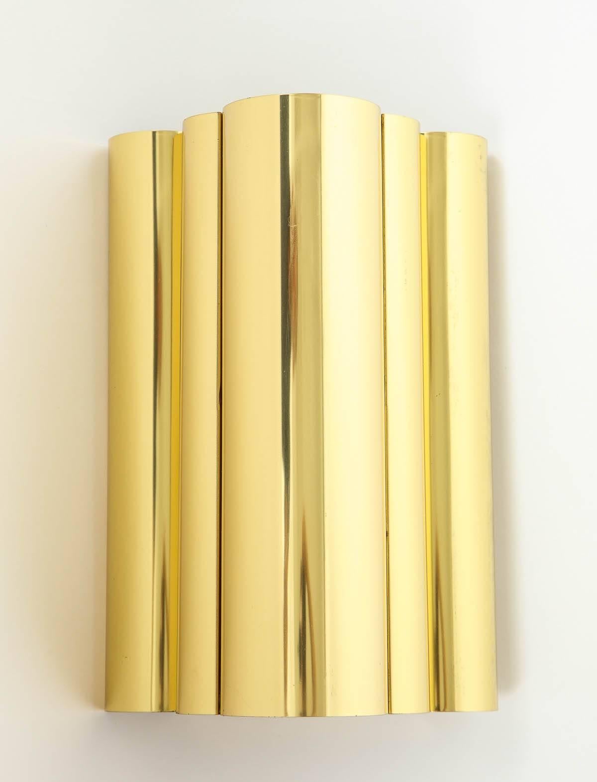 Pair of sleek brass sconces with a curvilinear form which gives an ambient glow when illuminated. Rewired for use in USA.