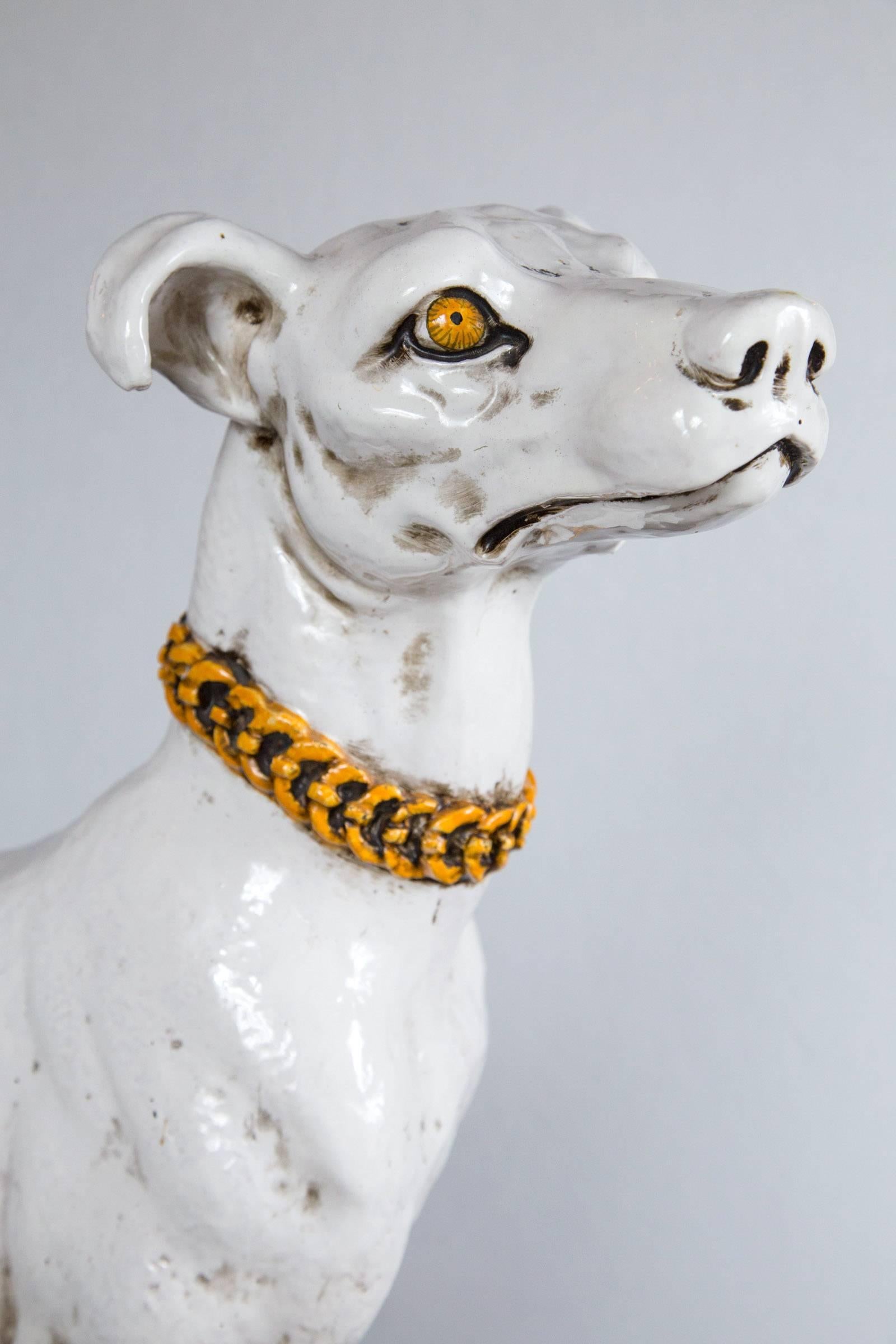 This dog is in a sitting position. He has a white body, a yellow collard and yellow eyes. He sits on an integral base. Repairs, as shown.
Measurements are for the base.