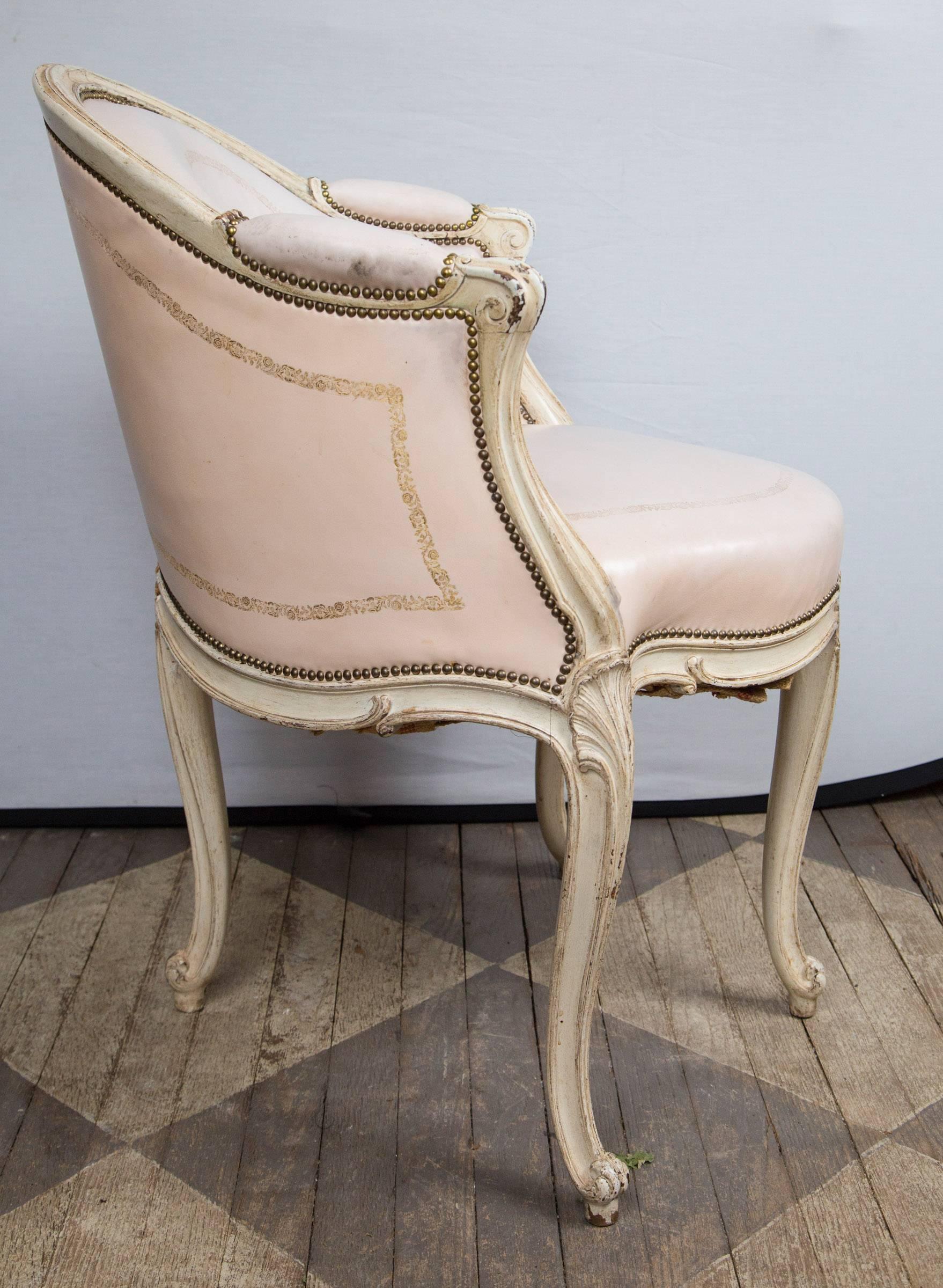 Cream colored paint with gold embossed pale pink leather. Leaf carving at top of the cabriolet legs, with curled toes.