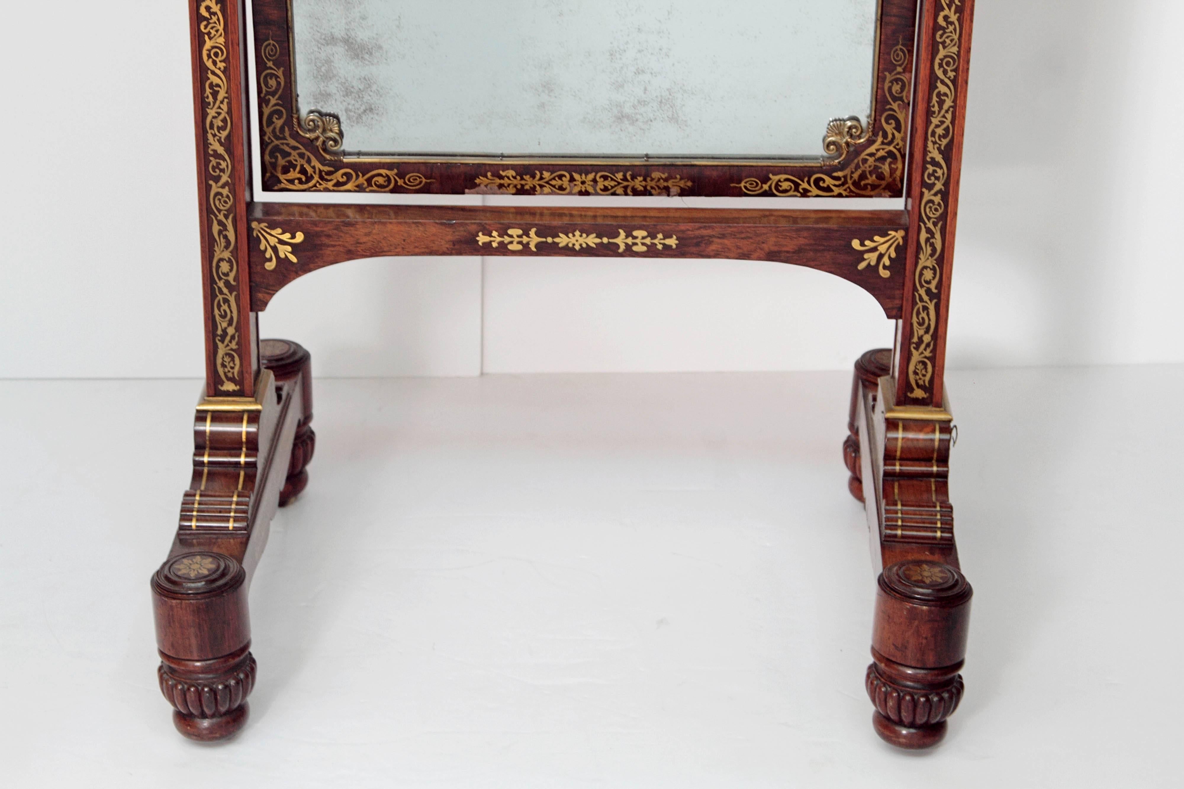 English Regency neoclassical rosewood cheval mirror elaborately decorated with brass inlay.