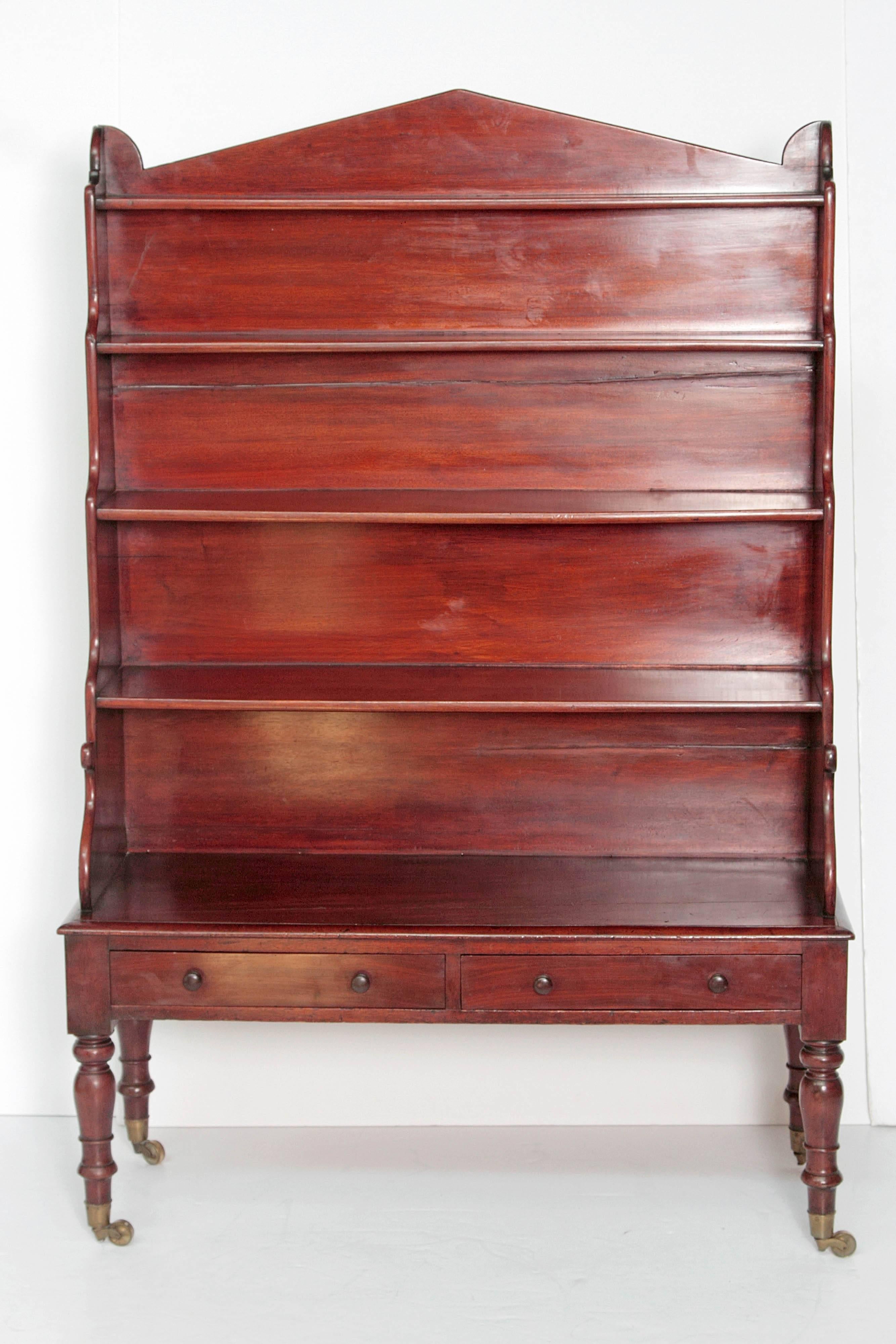 Period Regency
Dwarf Waterfall bookcases / etageres, pair
Manner of Gillows of Lancaster / London
each with two (2) drawers
mahogany case with turned mahogany legs with brass castors 
English, circa 1820.

Measures: 62.75