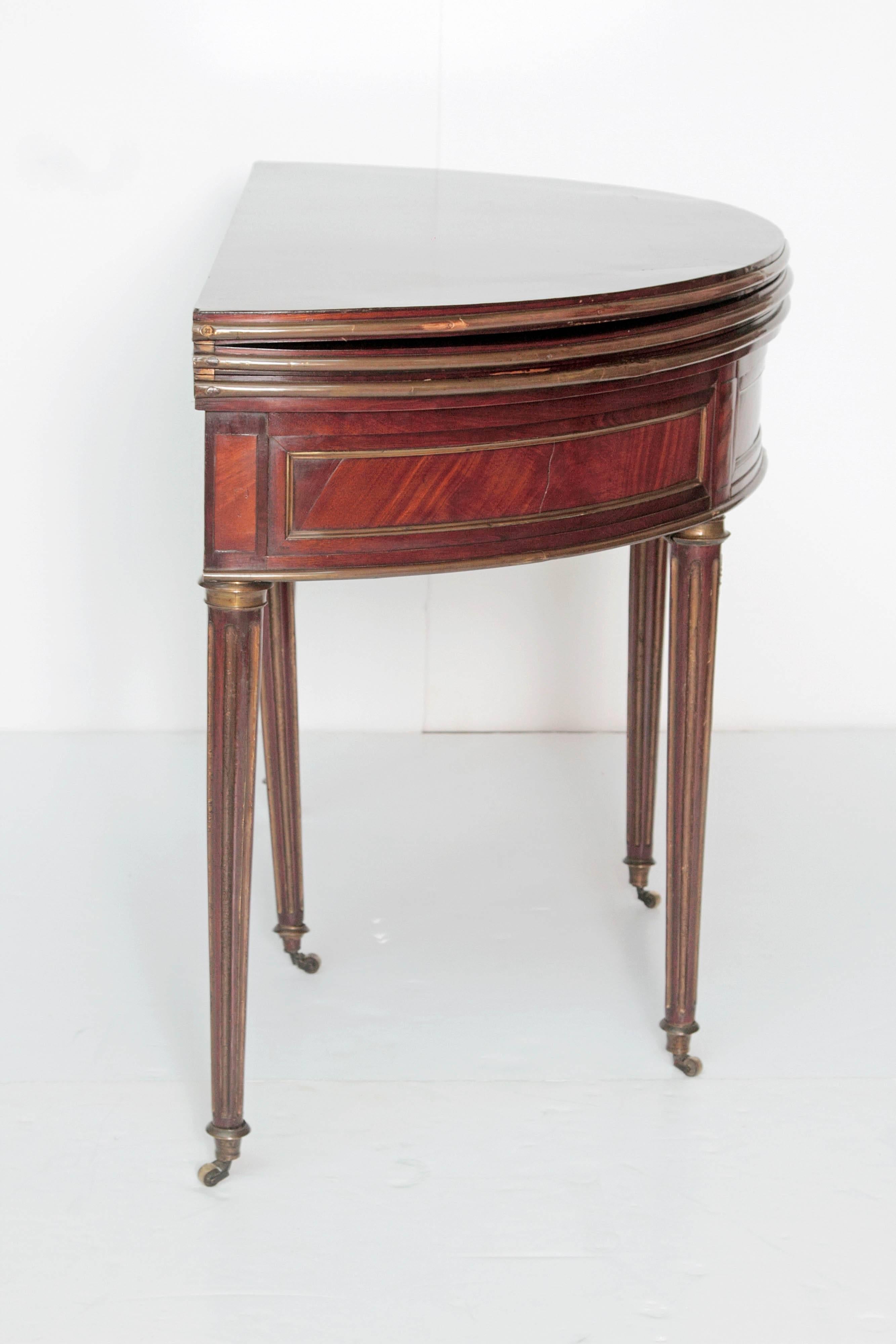A demilune Directoire triple top games table of mahogany with decorative brass bands, green baize top for cards (when open), also opens to beautiful round 42.5