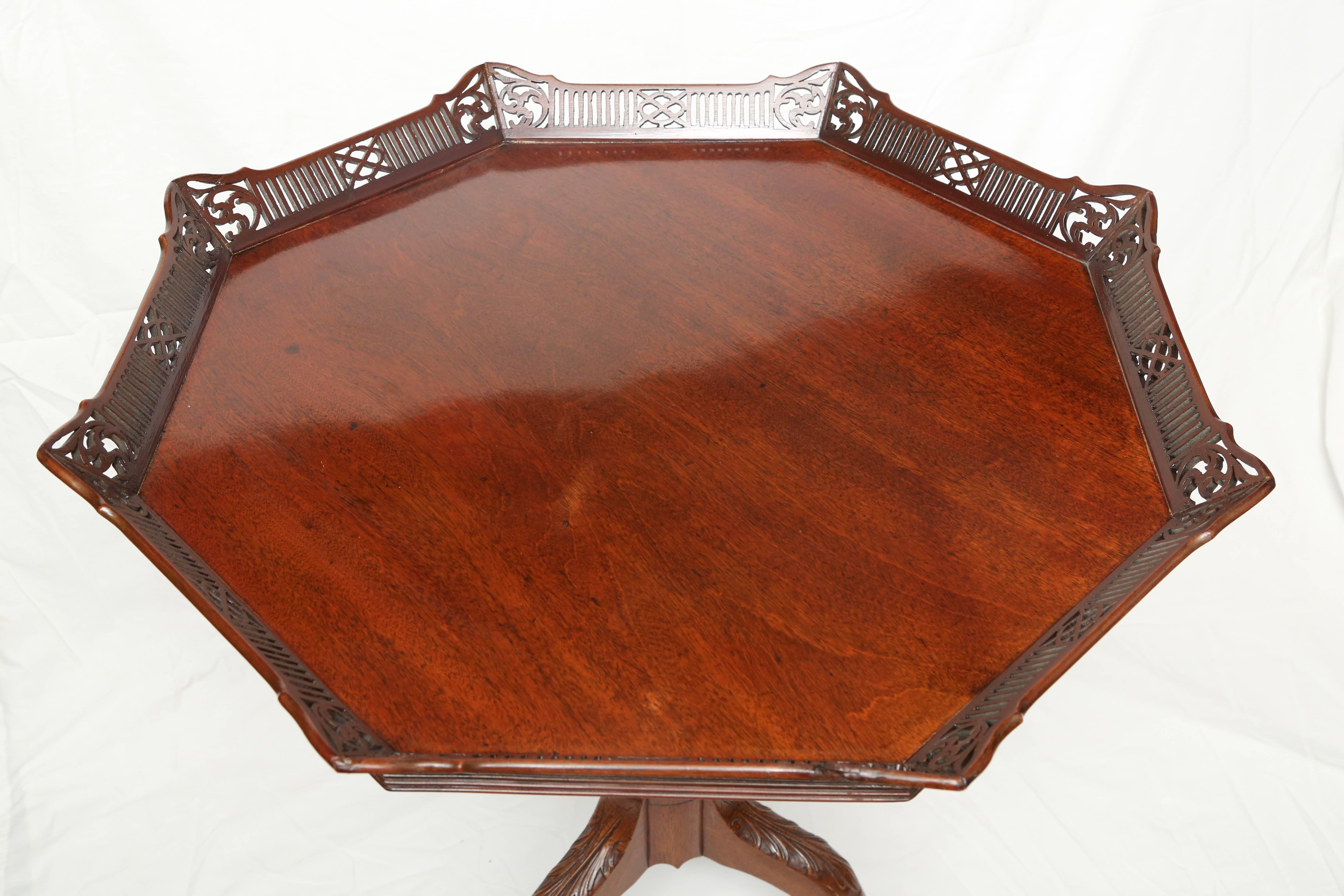 featuring a tilting octagonal top with a reticulated gallery, raised on an urn carved standard with three cabriole legs.