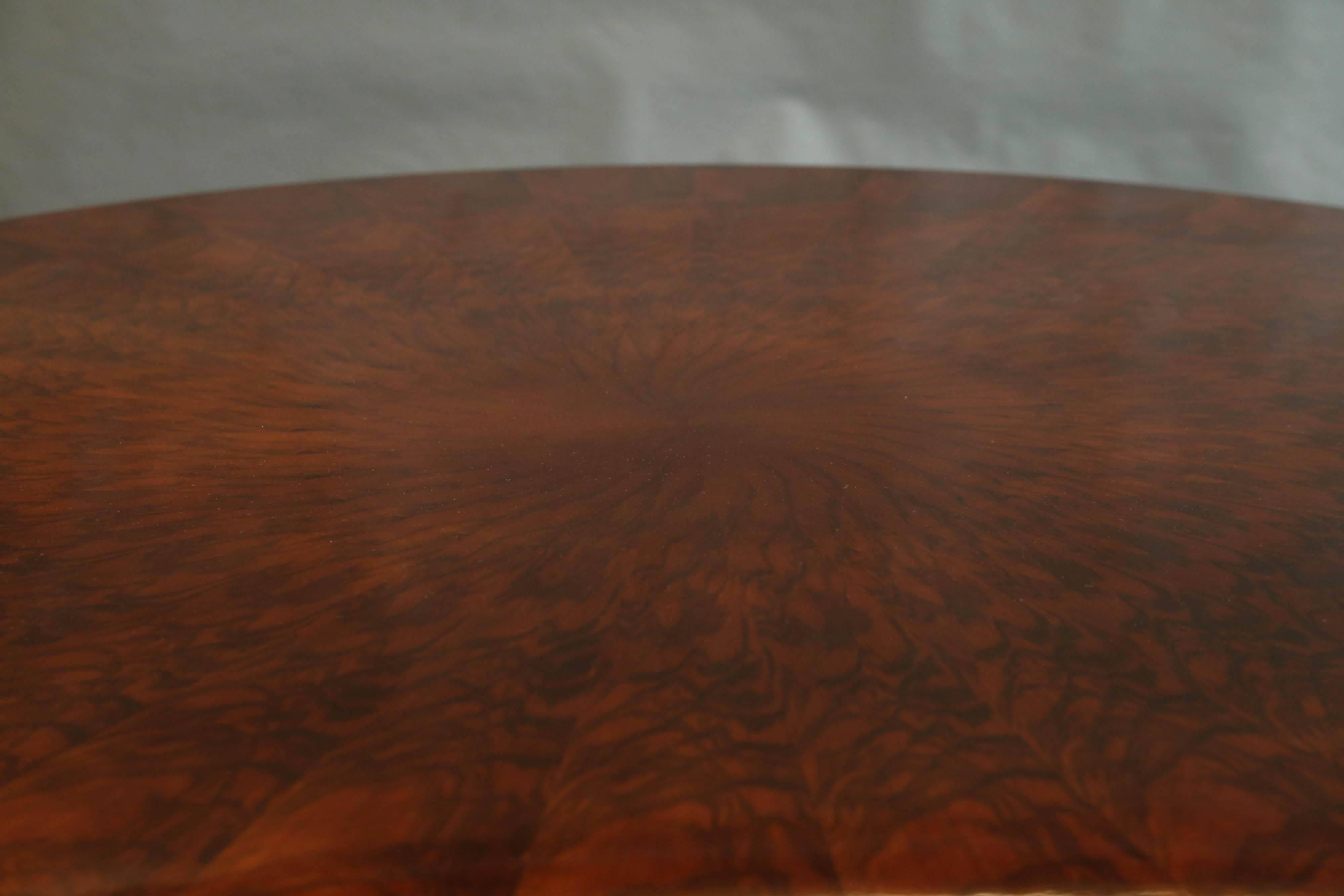 Round tabletop is made out of walnut and presents the beauty of the wood. The wood pattern is placed the certain way to create the imitation of sun rays, which are bursting out of focal point in the middle of the tabletop. It rests on a sculpted