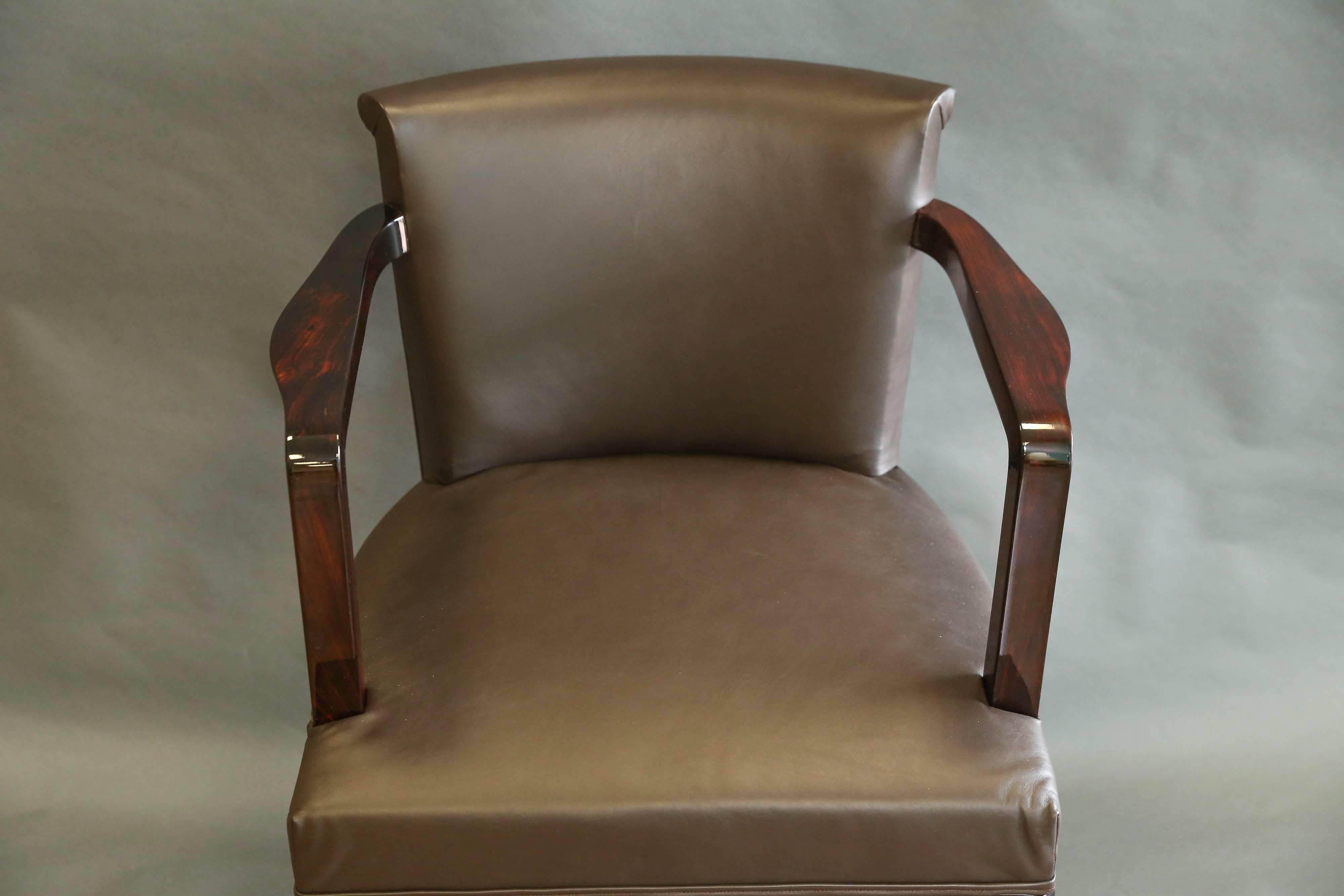 Office chair is done in a fine walnut wood, newly re-upholstered in brown leather. It has two armrests and elevated by the four elongated wooden legs. 
Condition is perfect. Restored.

Hungary, circa 1930s

Measures: 22” W x 21” D x 30” H.
 